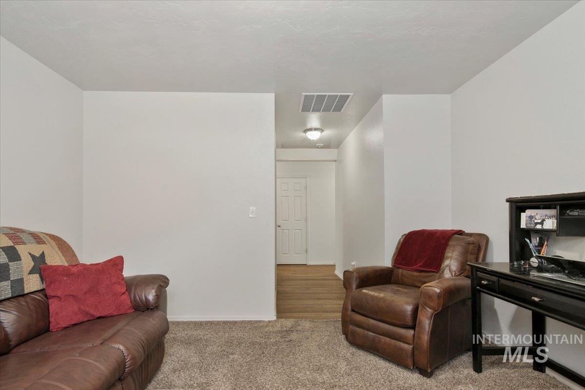Living area with carpet and a textured ceiling