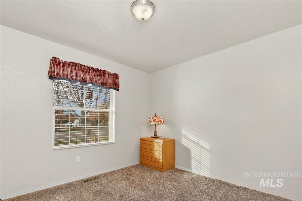 Carpeted empty room with baseboards