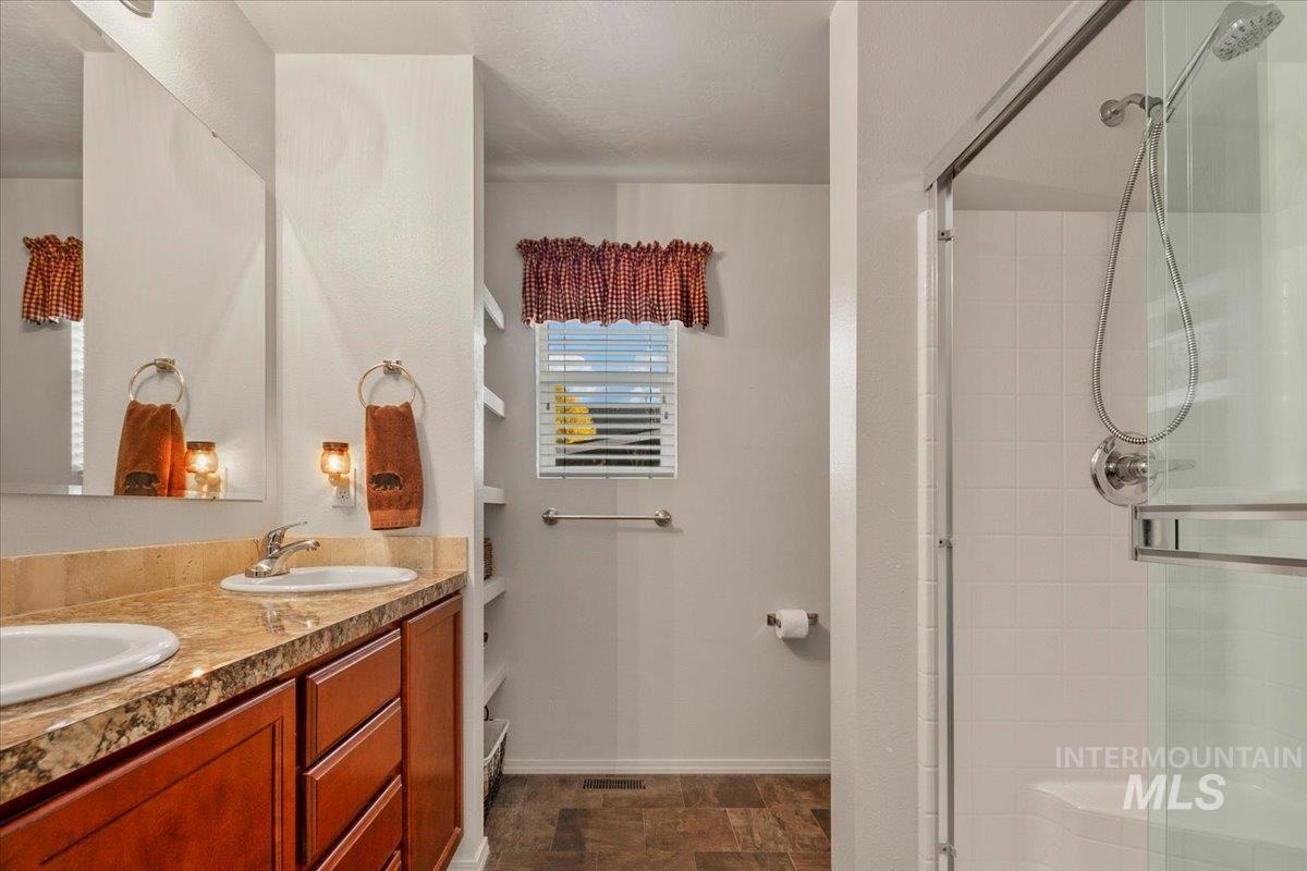 Bathroom with double vanity and a shower stall