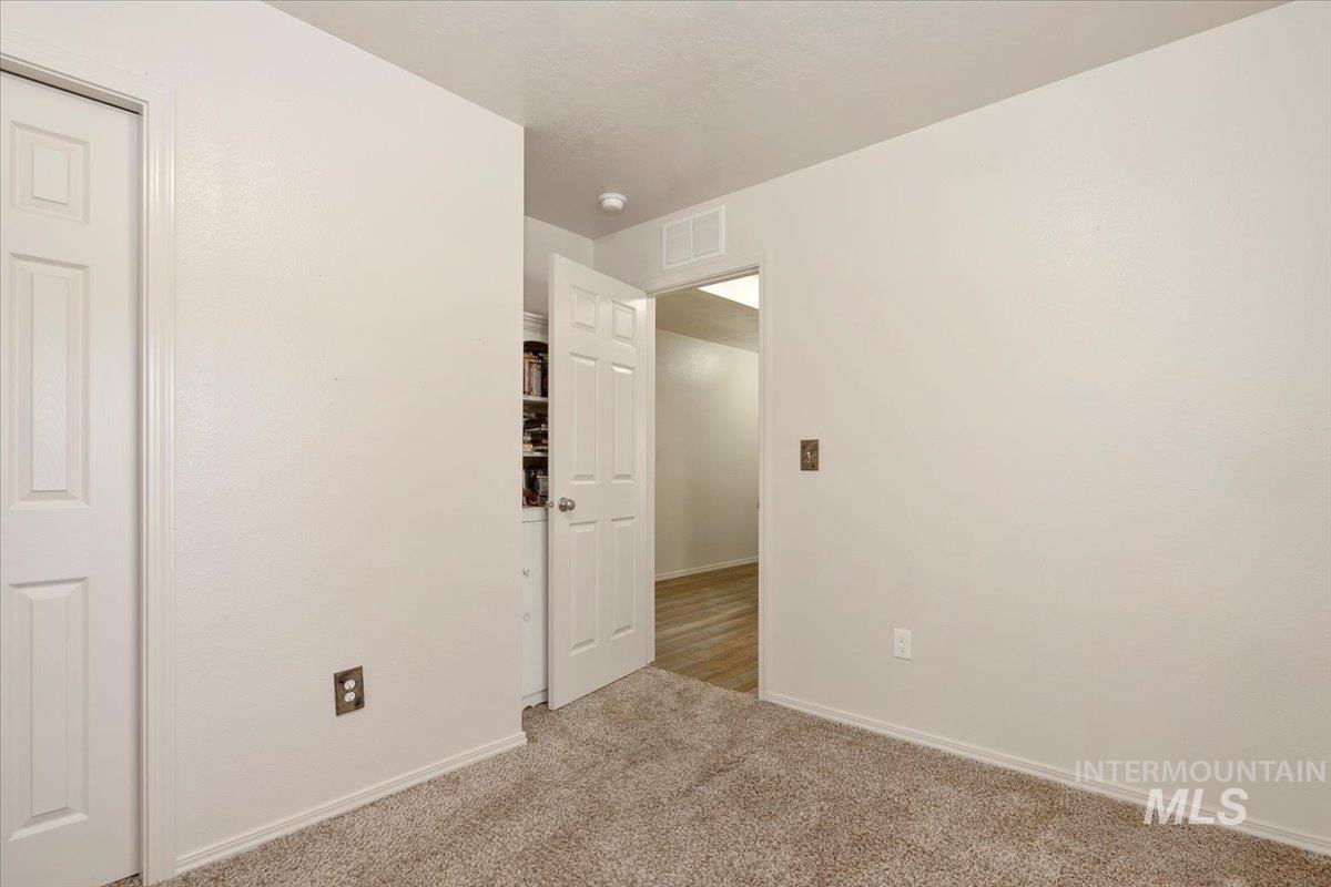 Carpeted spare room featuring baseboards