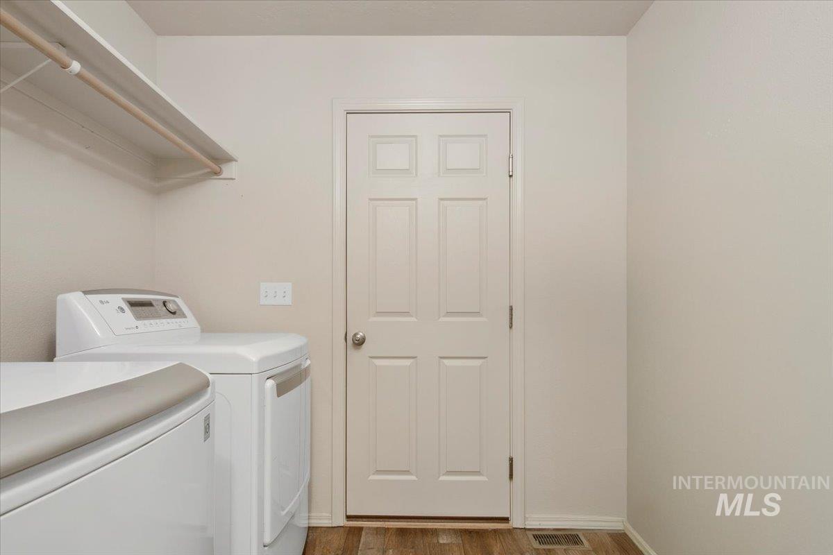 Laundry room featuring independent washer and dryer and dark wood-type flooring