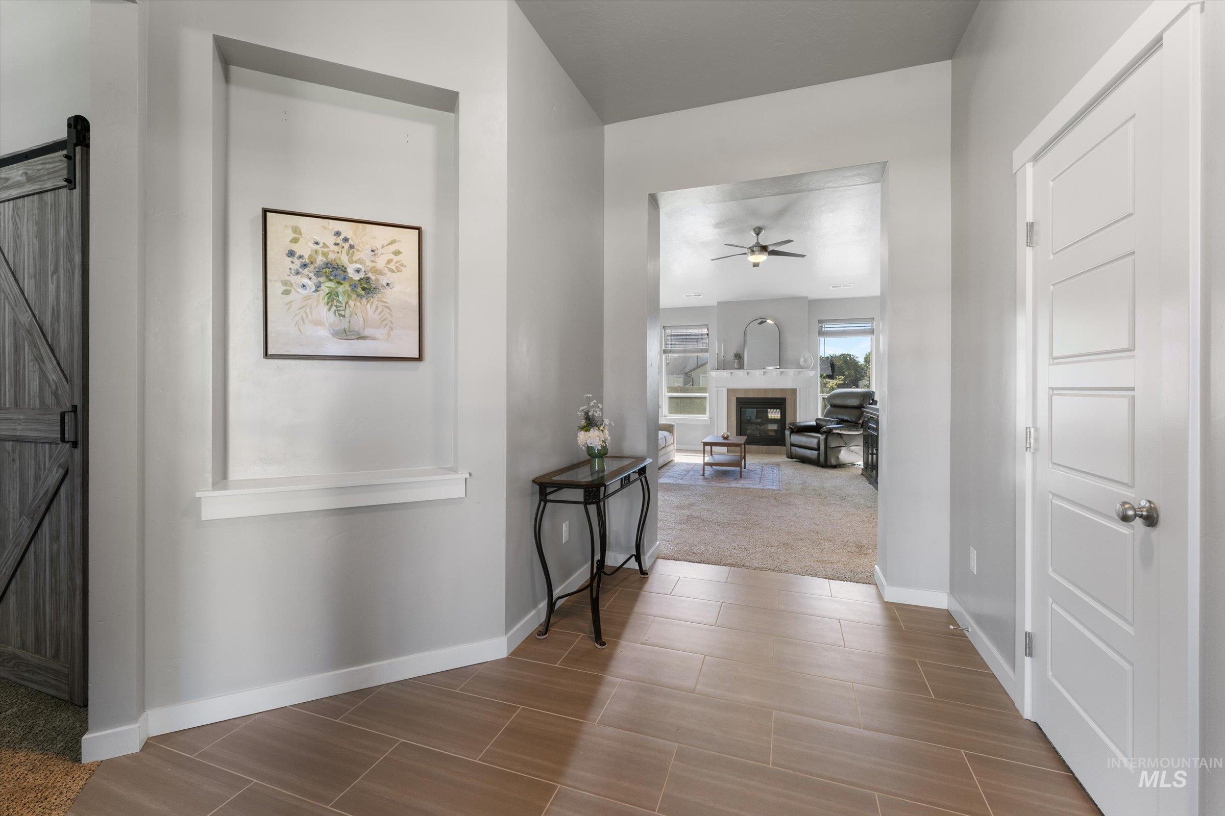 Hallway with a barn door and baseboards