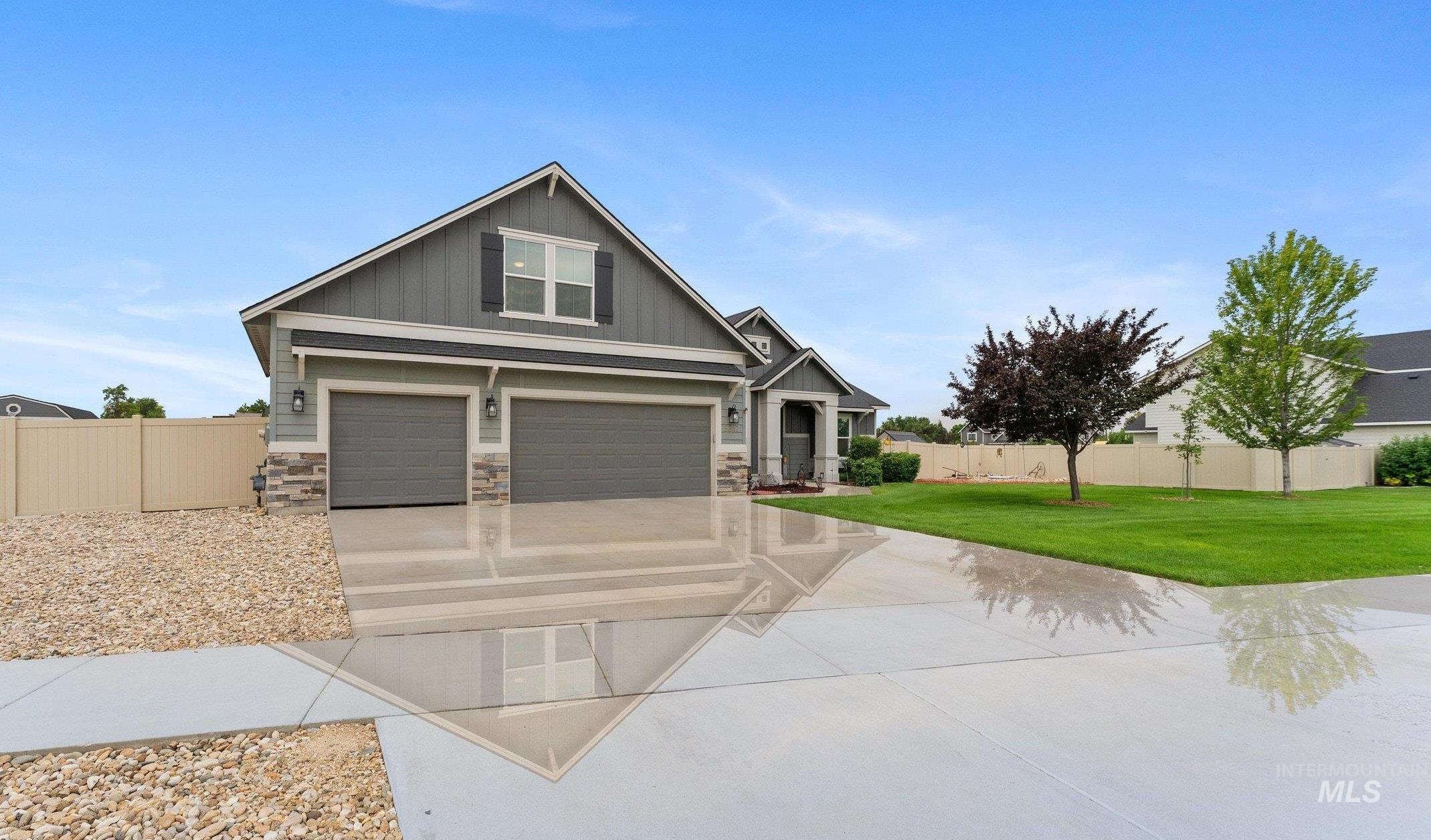 Craftsman house featuring board and batten siding, concrete driveway, stone siding, and a garage