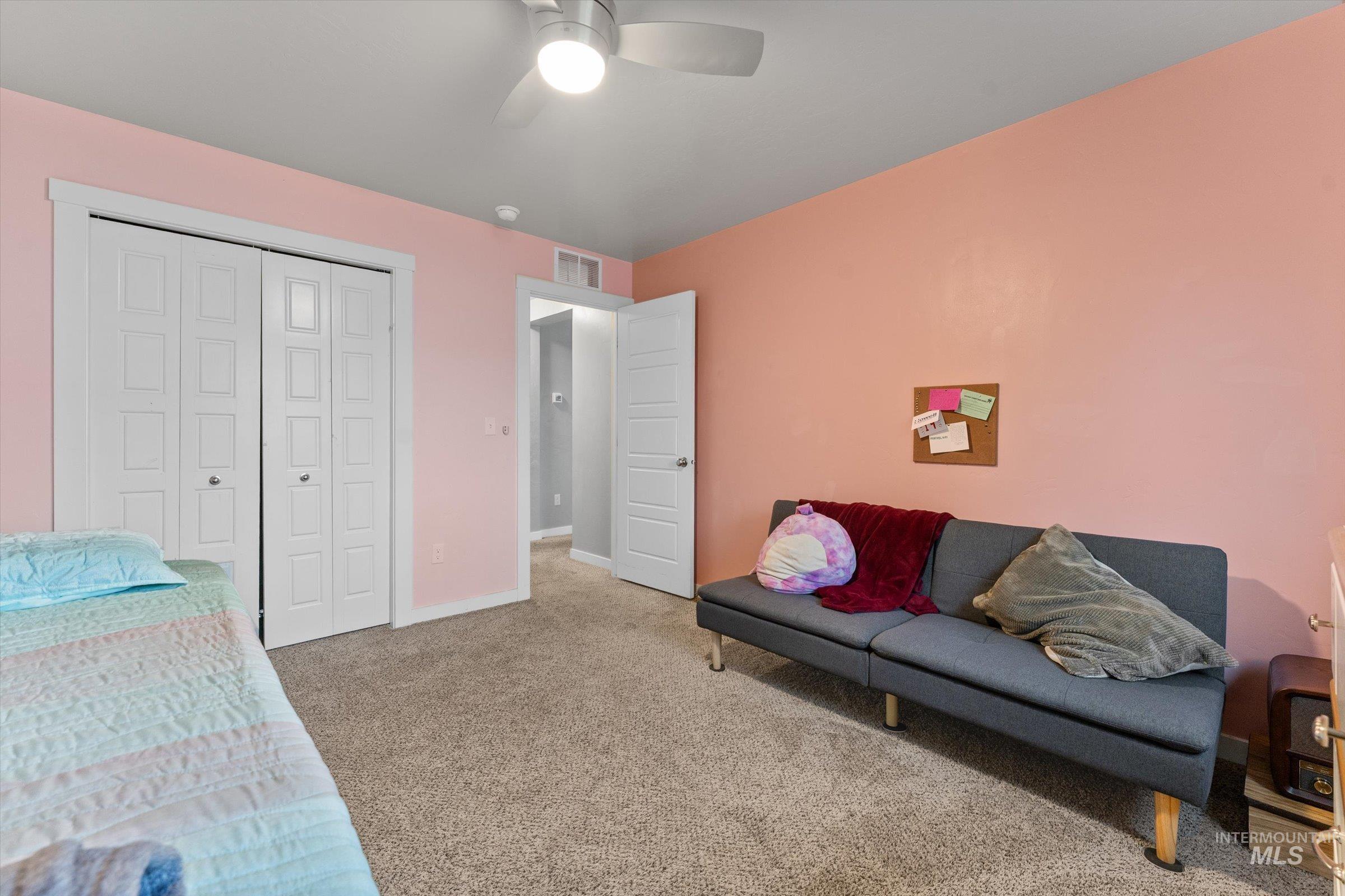 Bedroom with carpet floors, a closet, and a ceiling fan