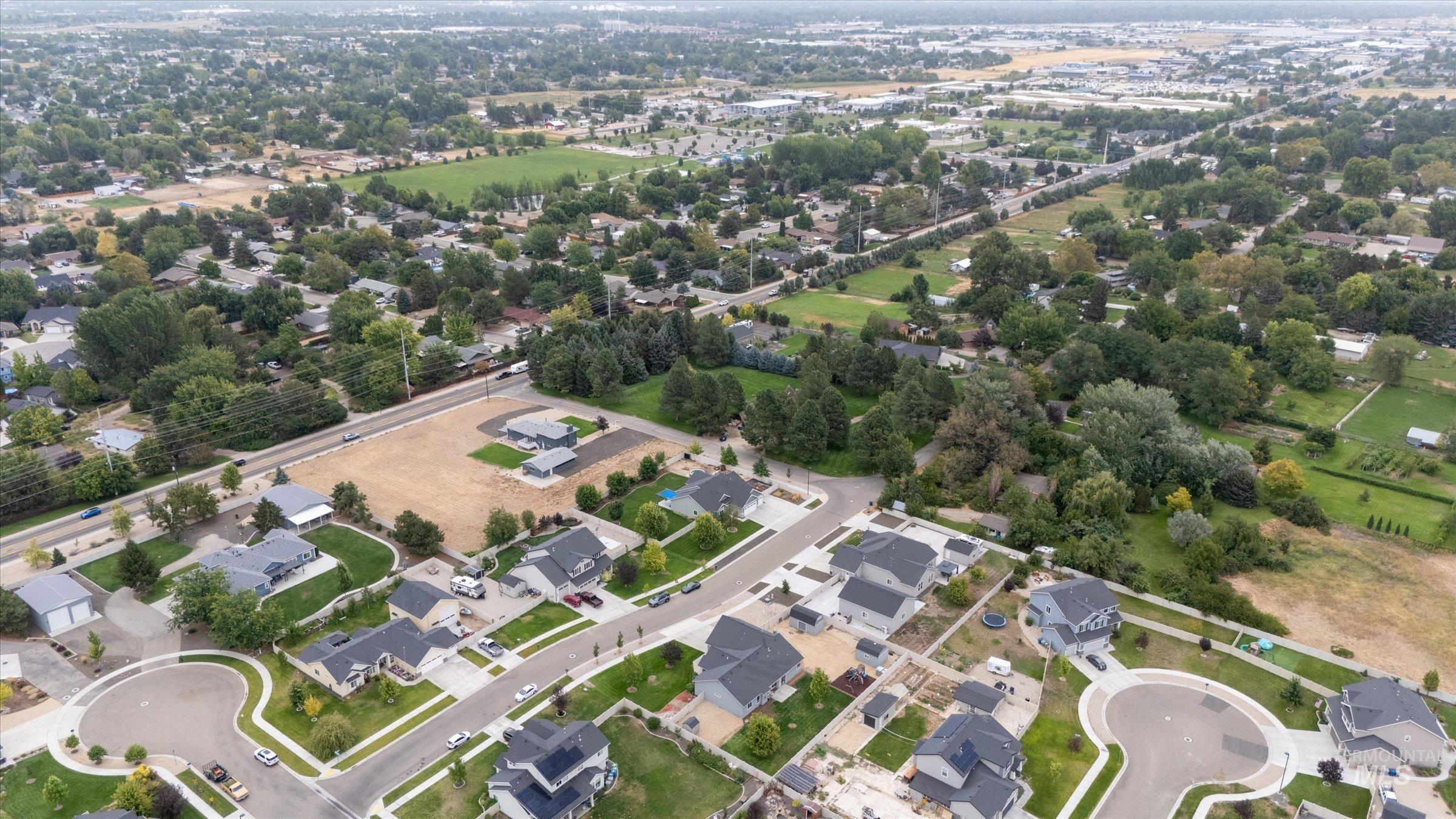 Aerial view of property and surrounding area with nearby suburban area
