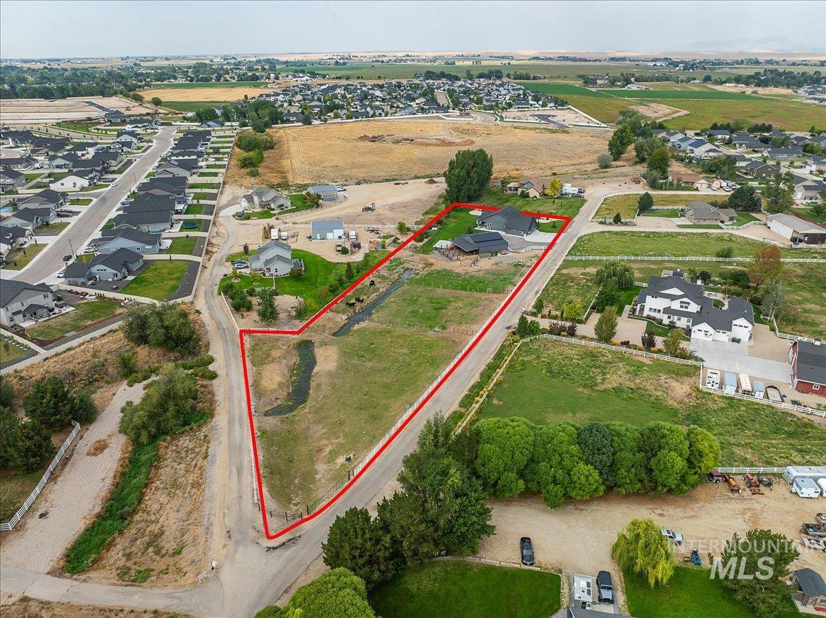 Aerial view of property's location featuring property parcel outlined and nearby suburban area