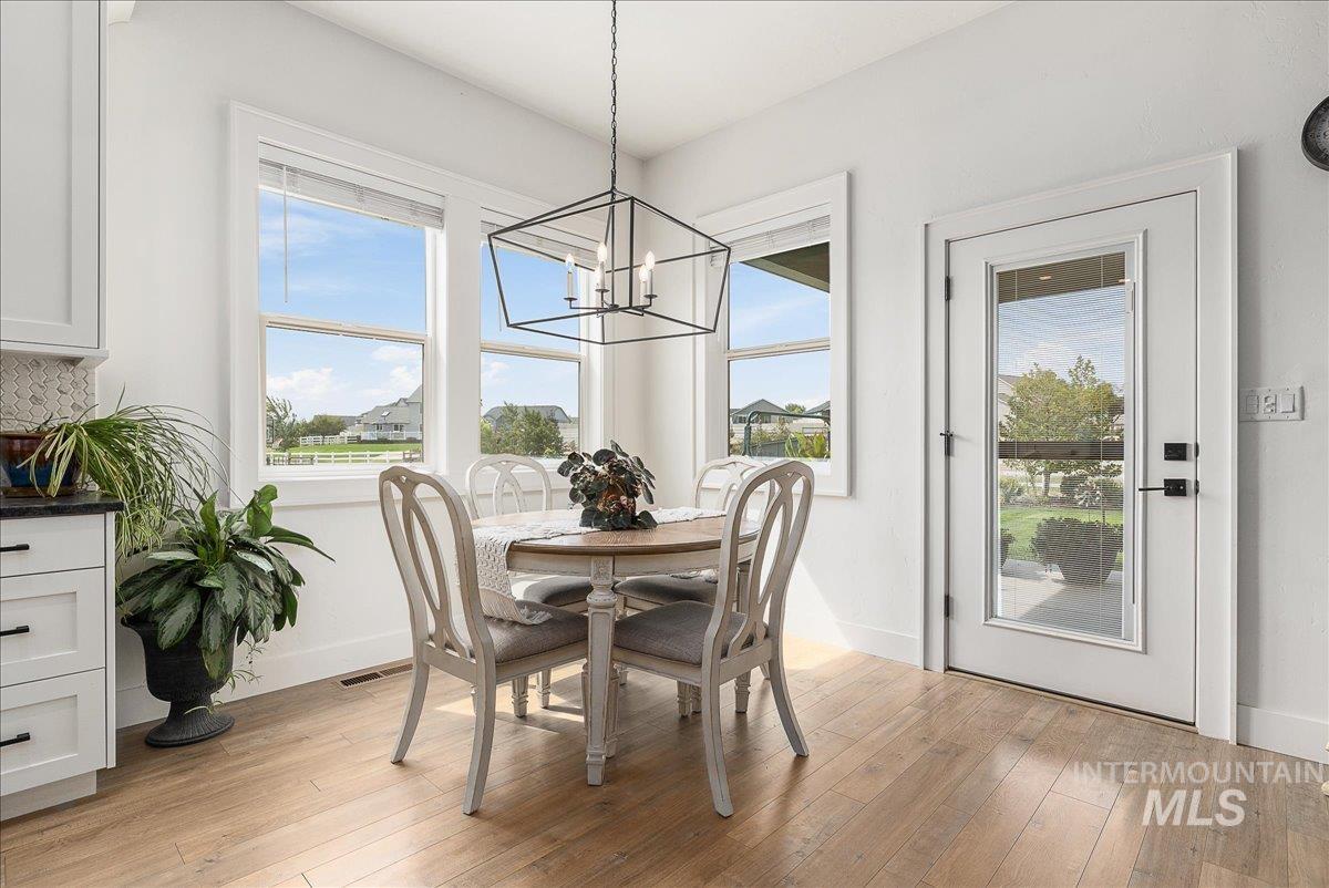 Dining area with light wood-type flooring and a chandelier