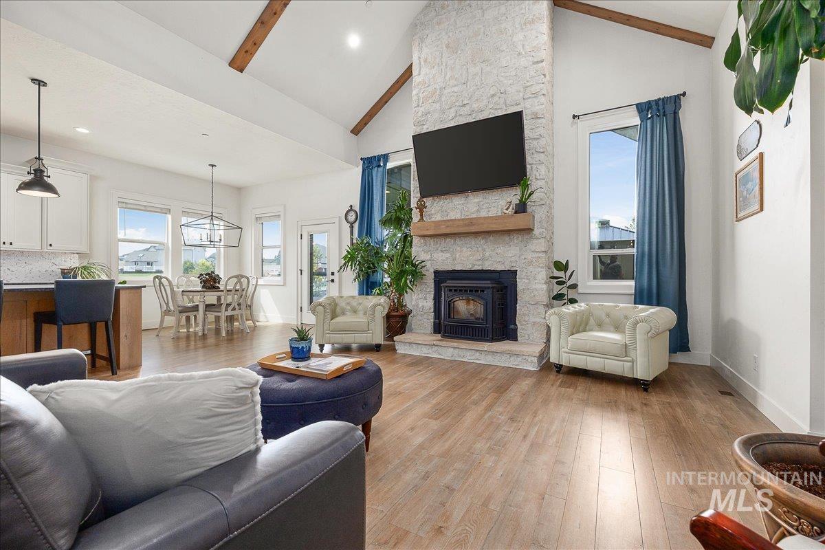 Living area featuring wood finished floors, high vaulted ceiling, recessed lighting, and a fireplace