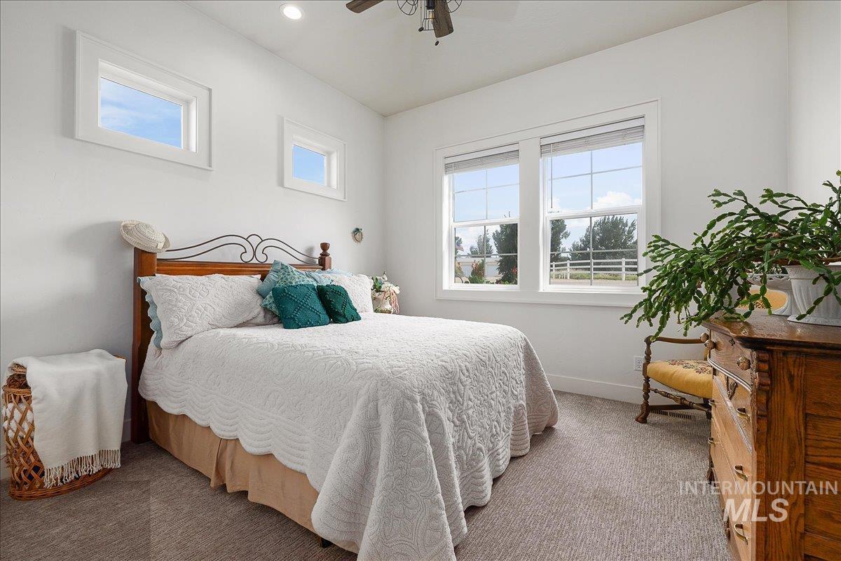 Carpeted bedroom featuring baseboards and a ceiling fan