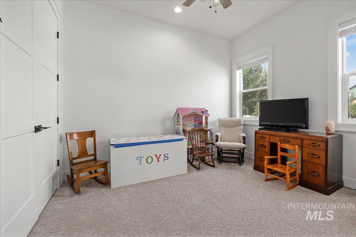 Carpeted home office with a ceiling fan and recessed lighting