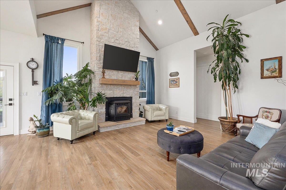 Living room featuring high vaulted ceiling, light wood-style floors, recessed lighting, and beam ceiling
