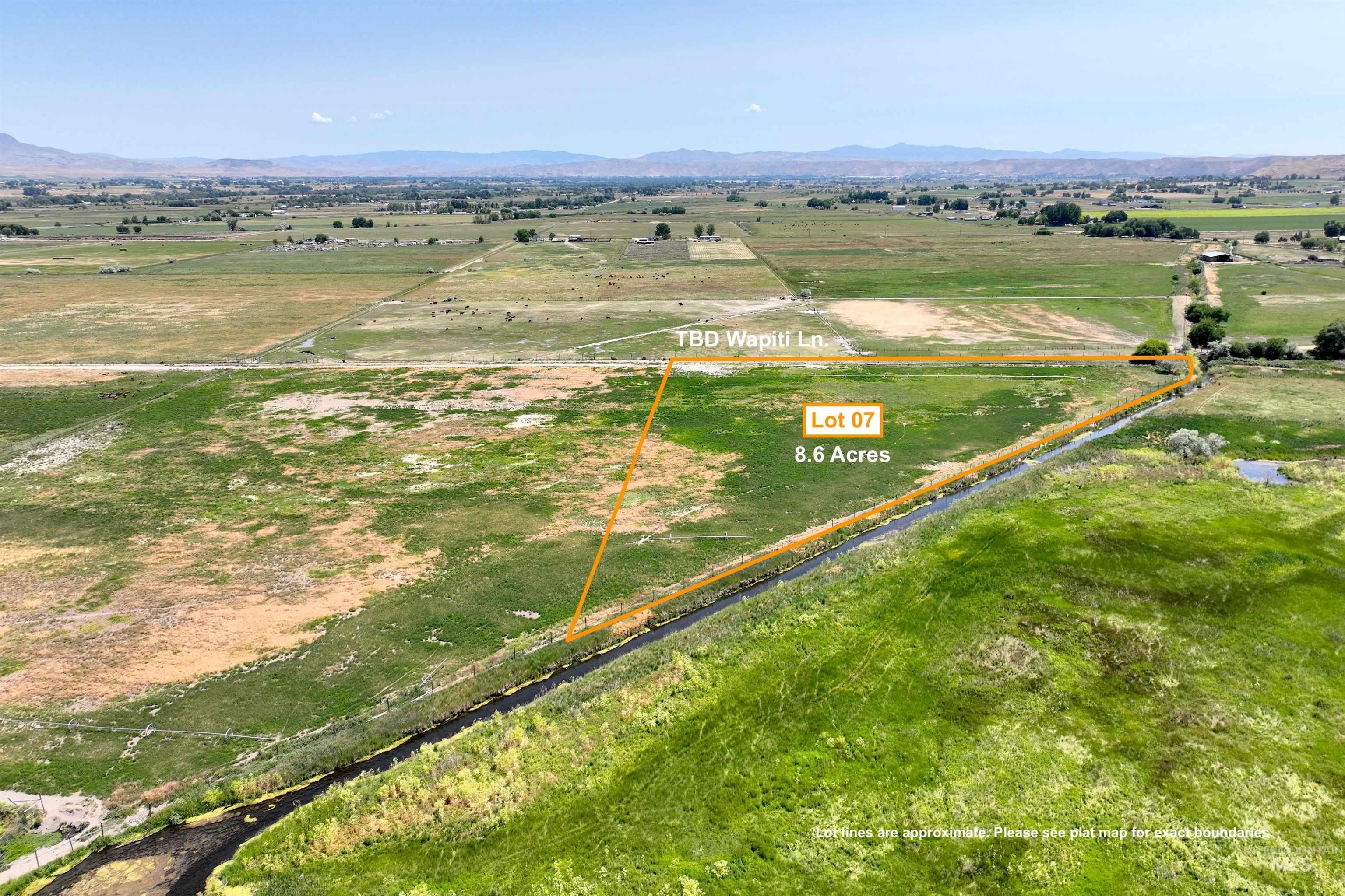 Aerial view of sparsely populated area with property parcel outlined and a mountain backdrop