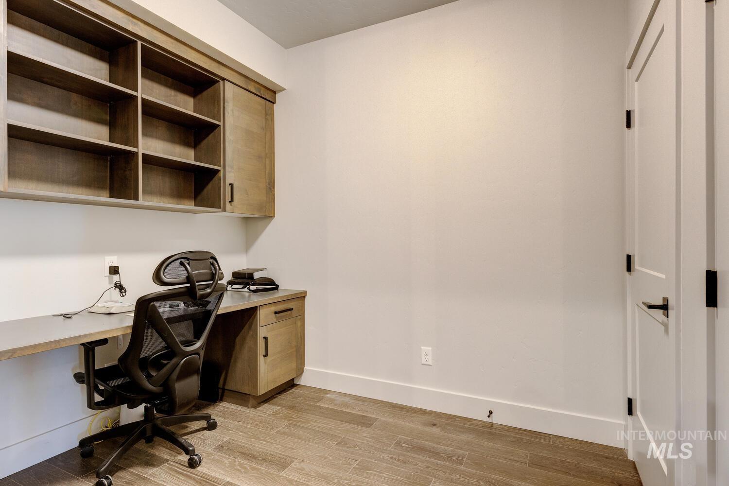 Office space with light wood-style flooring and built in study area