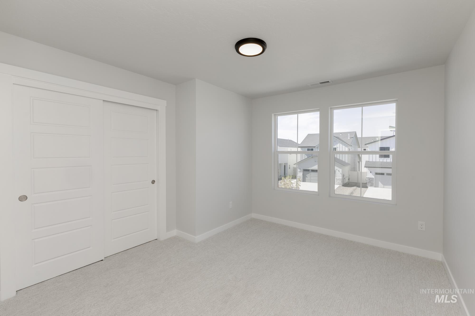 Unfurnished bedroom featuring light colored carpet and a closet