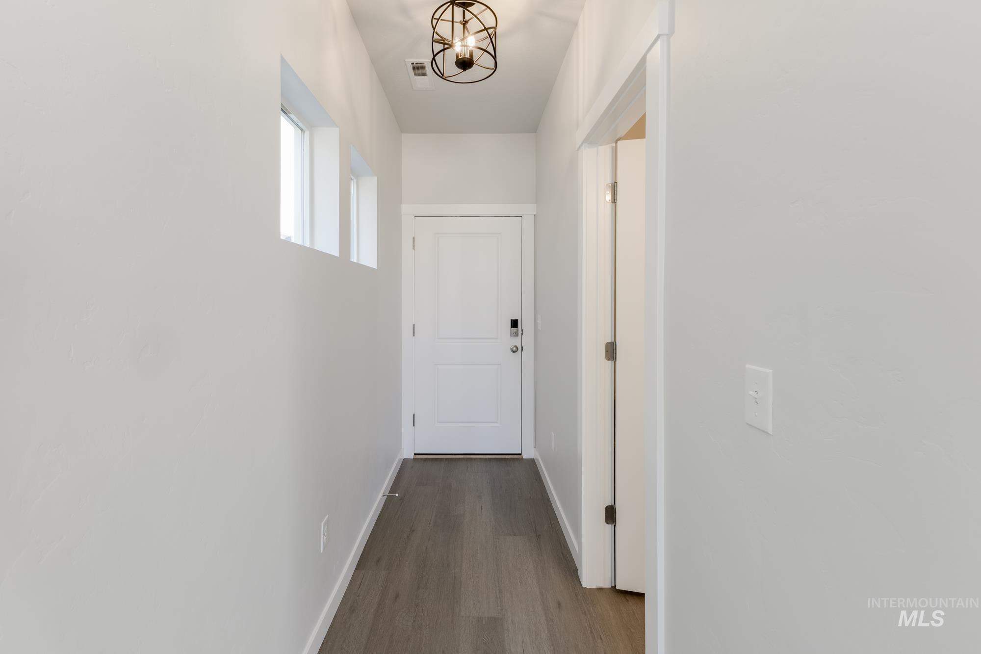 Hallway with baseboards and dark wood-type flooring