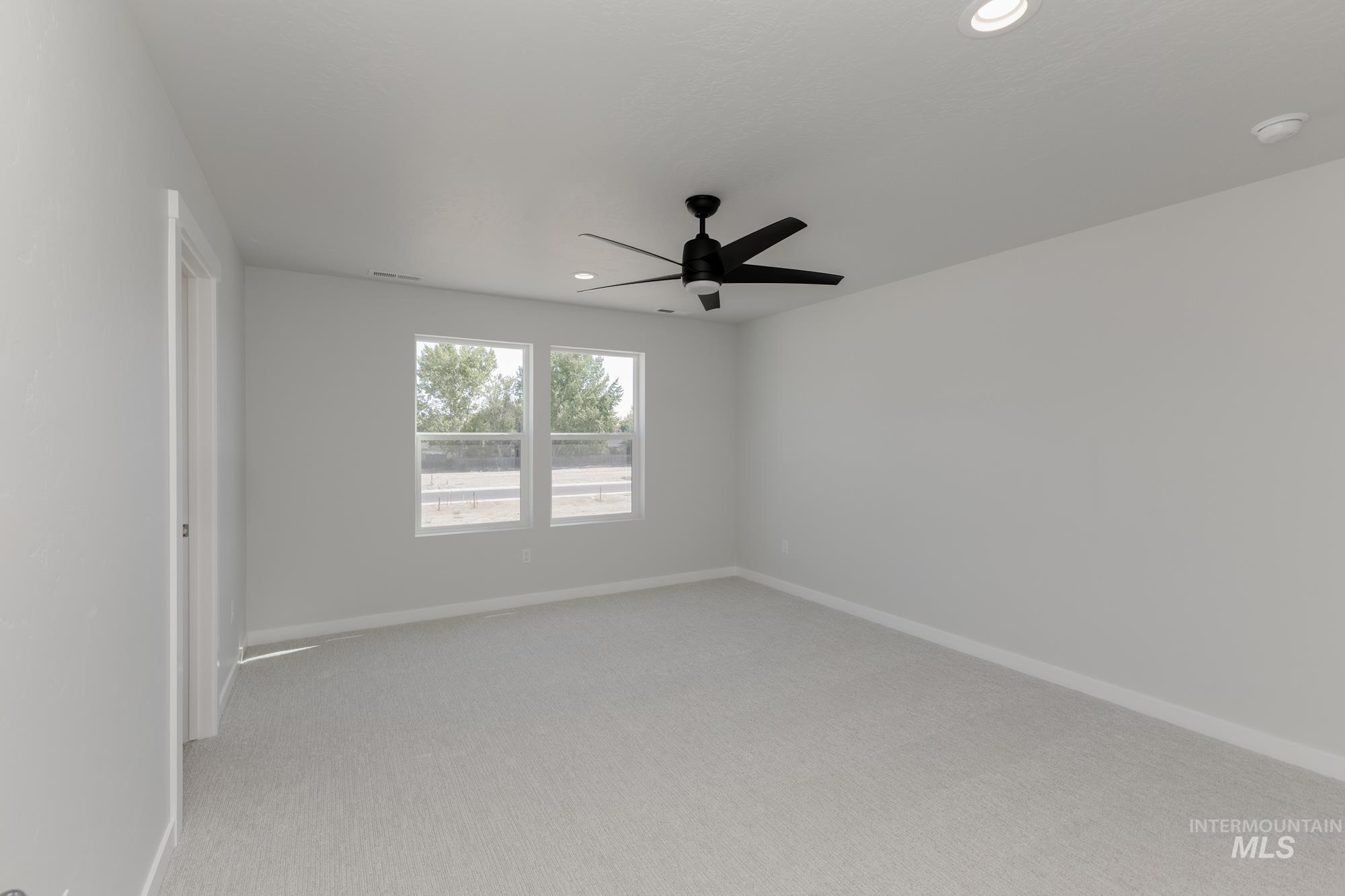 Spare room with light colored carpet, ceiling fan, and recessed lighting