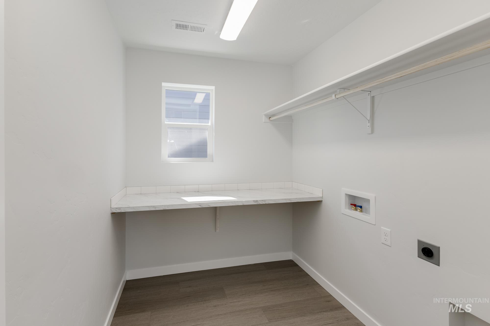 Laundry room featuring hookup for a washing machine, light wood-type flooring, and hookup for an electric dryer
