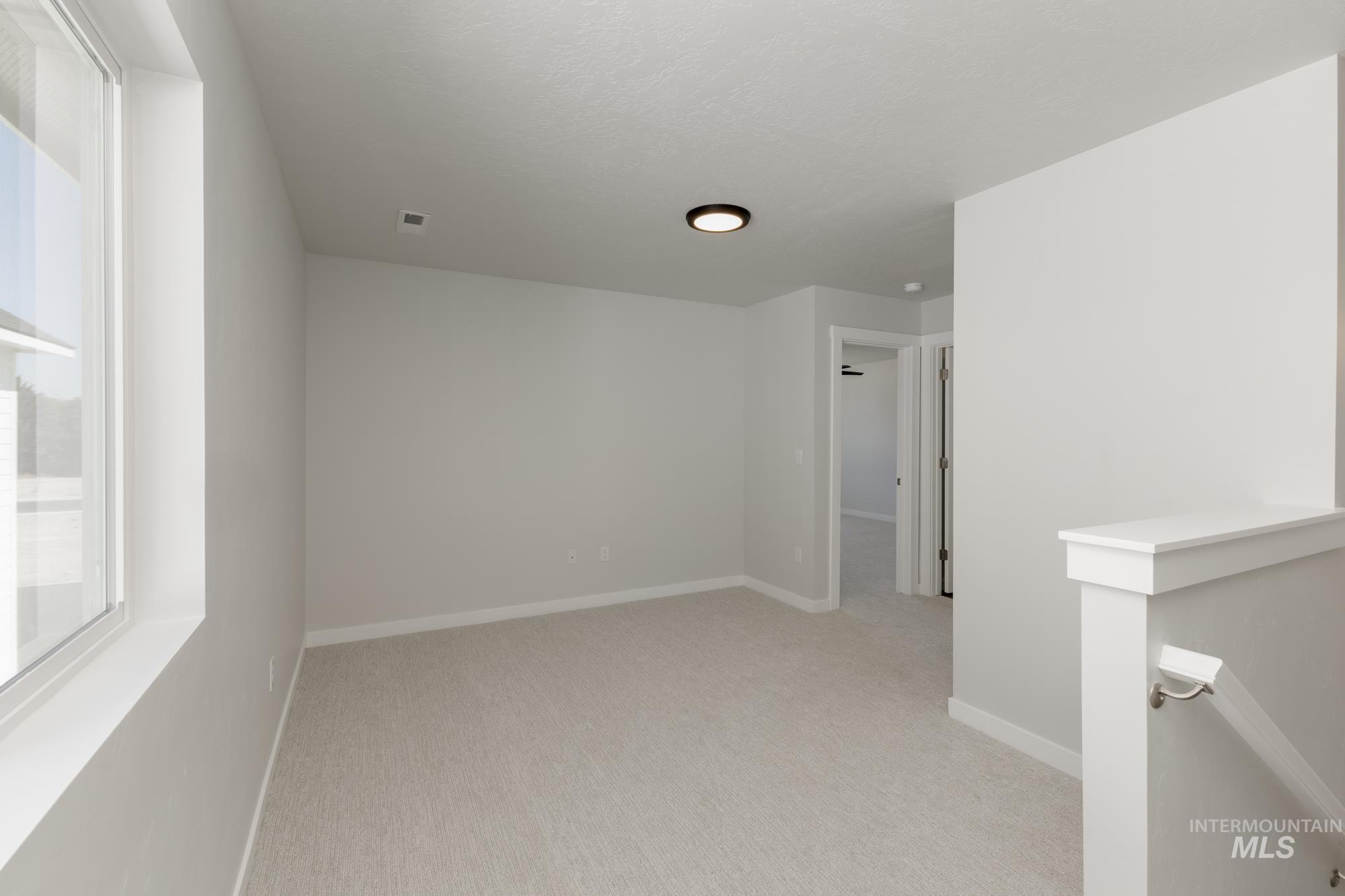 Unfurnished room with baseboards and light colored carpet