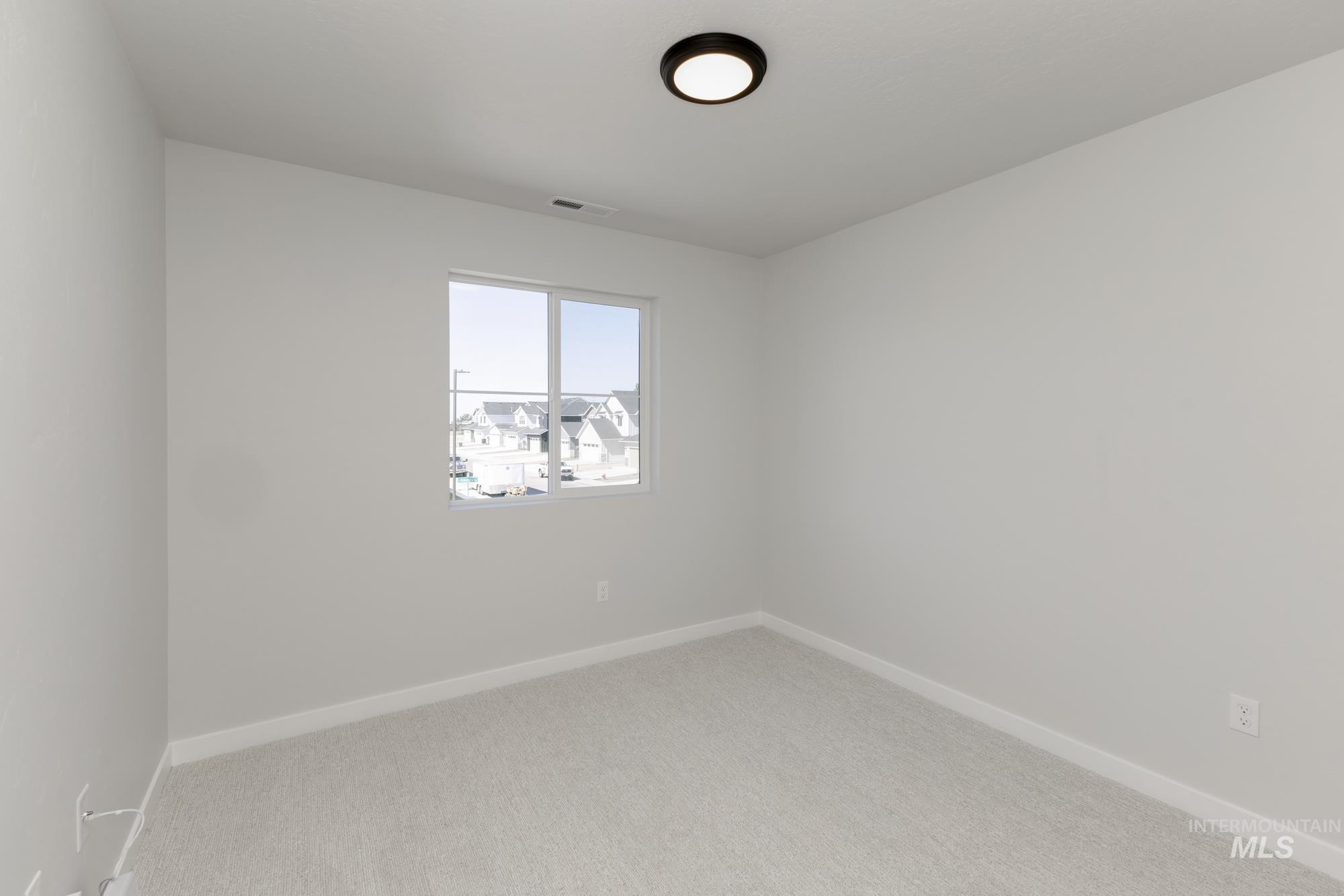 Carpeted empty room featuring baseboards