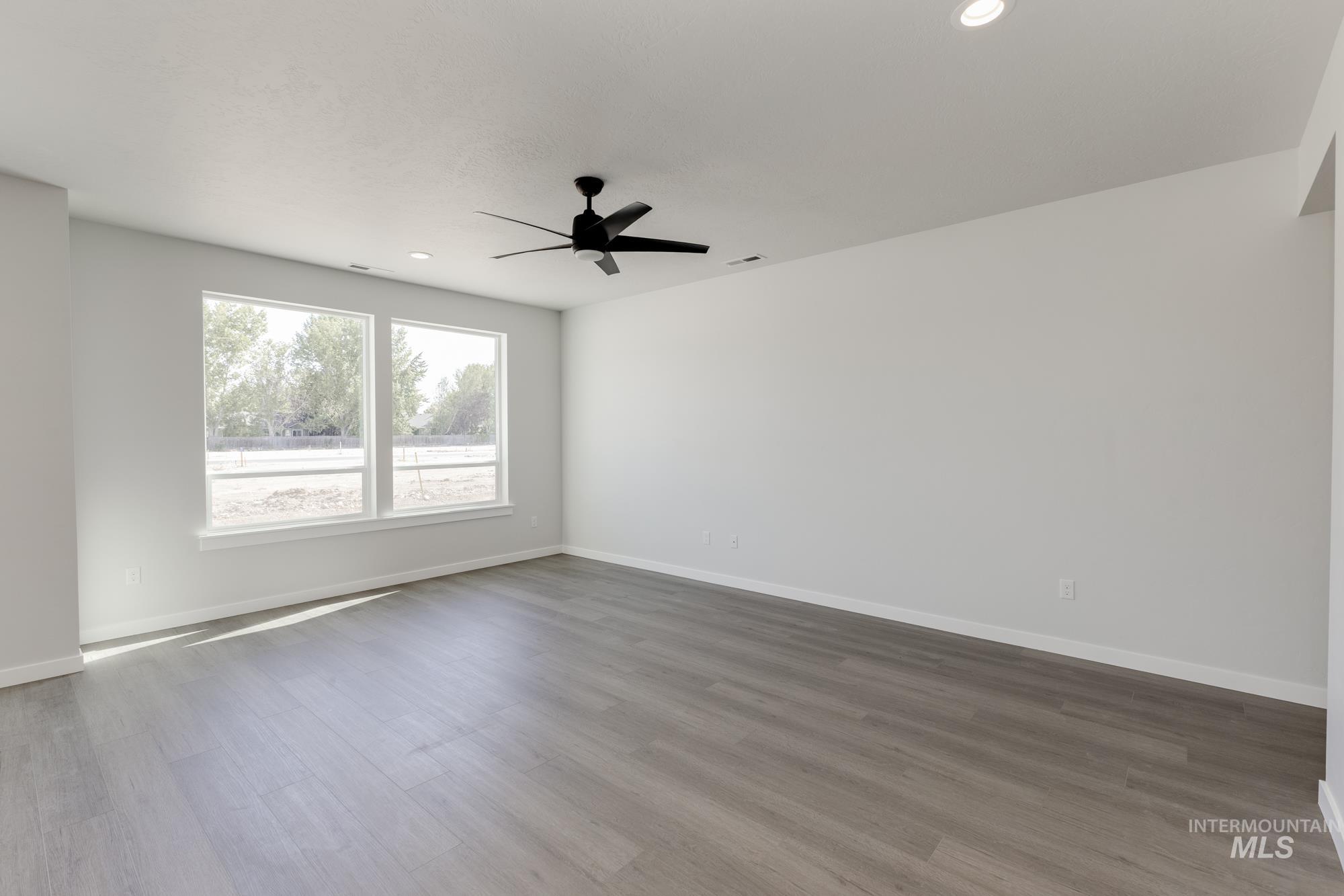 Spare room featuring light wood finished floors, recessed lighting, and a ceiling fan