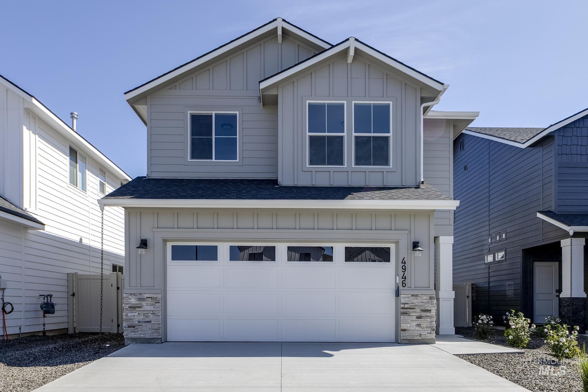 Craftsman house with board and batten siding, a shingled roof, and stone siding