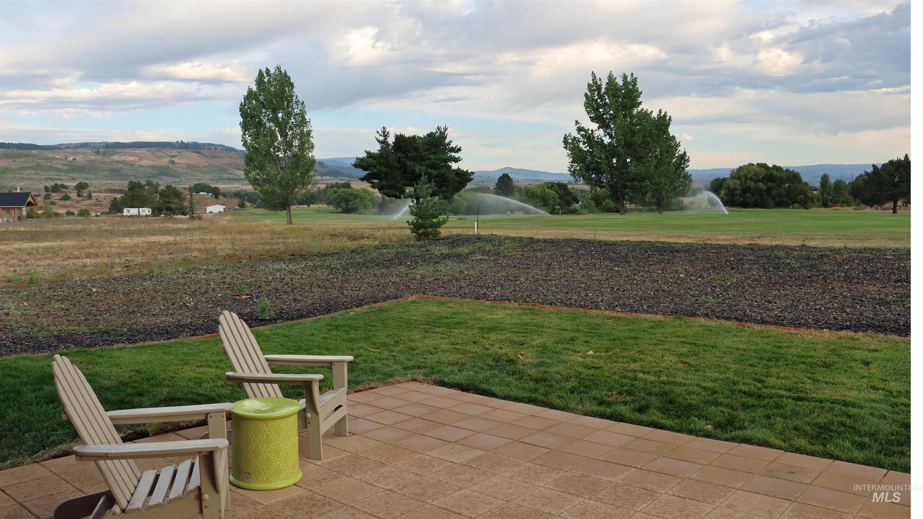 View of grassy yard with a patio area and a mountain view