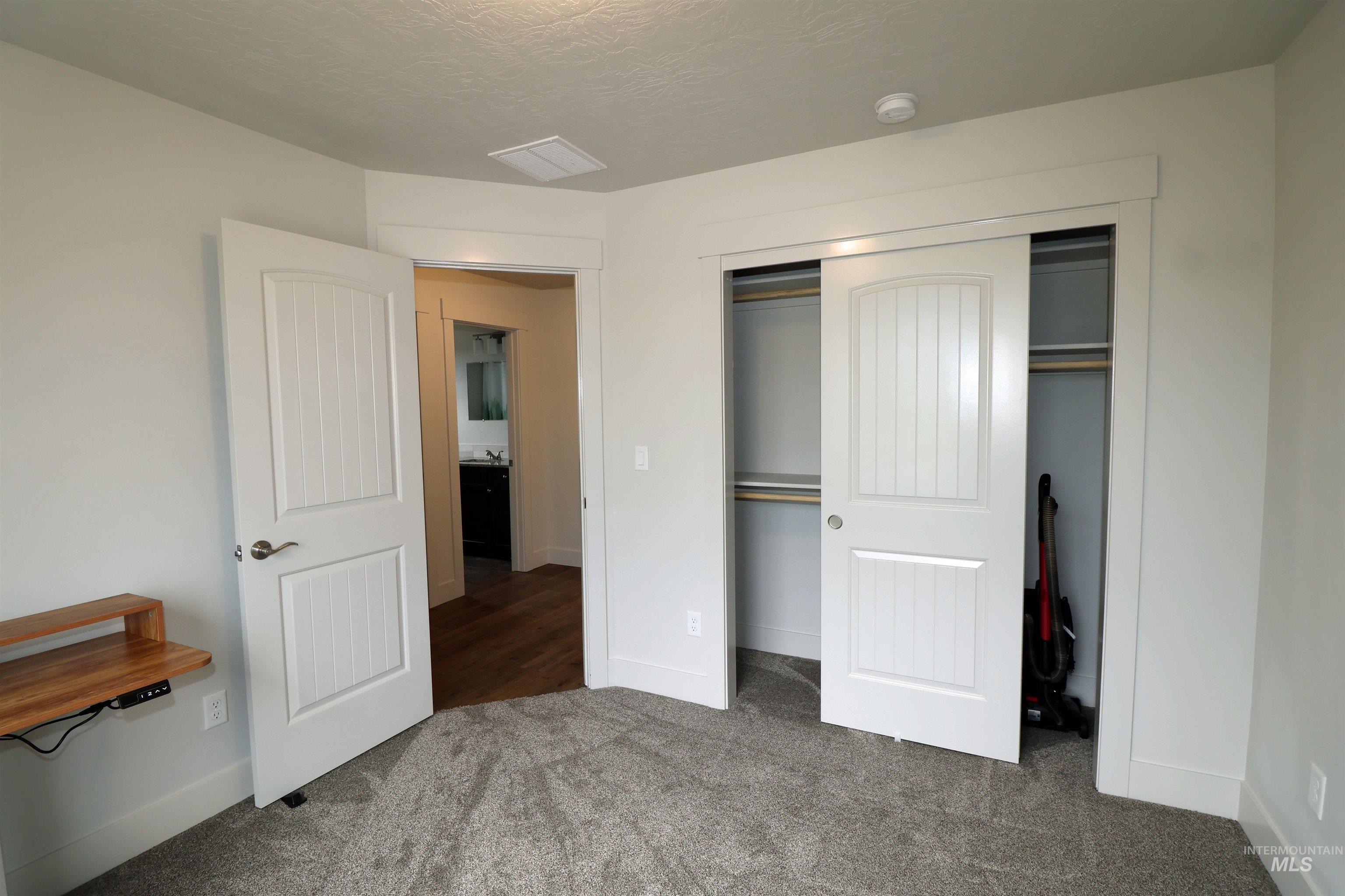 Unfurnished bedroom with carpet, a closet, and a textured ceiling