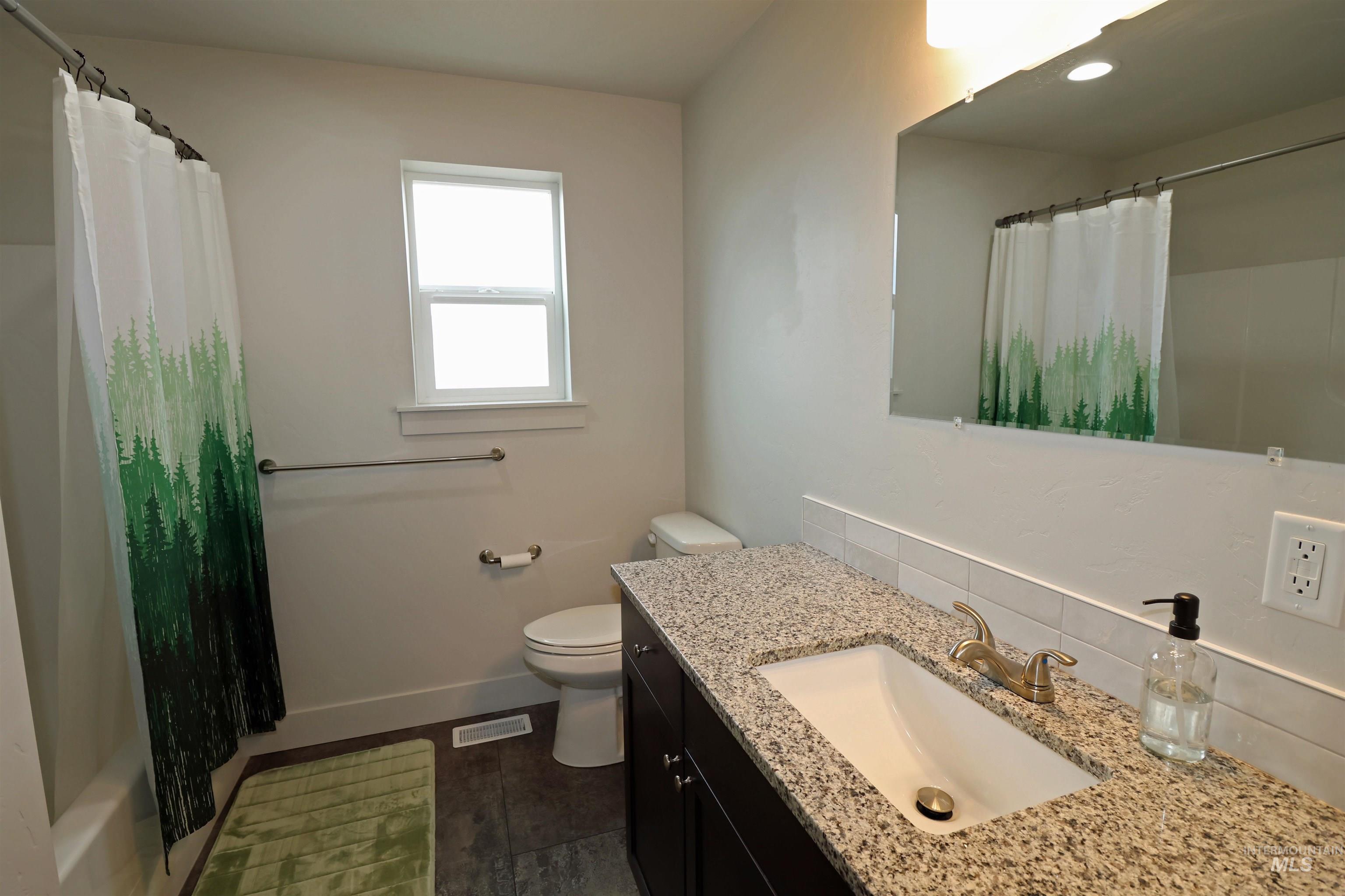 Bathroom featuring vanity and shower / tub combo with curtain