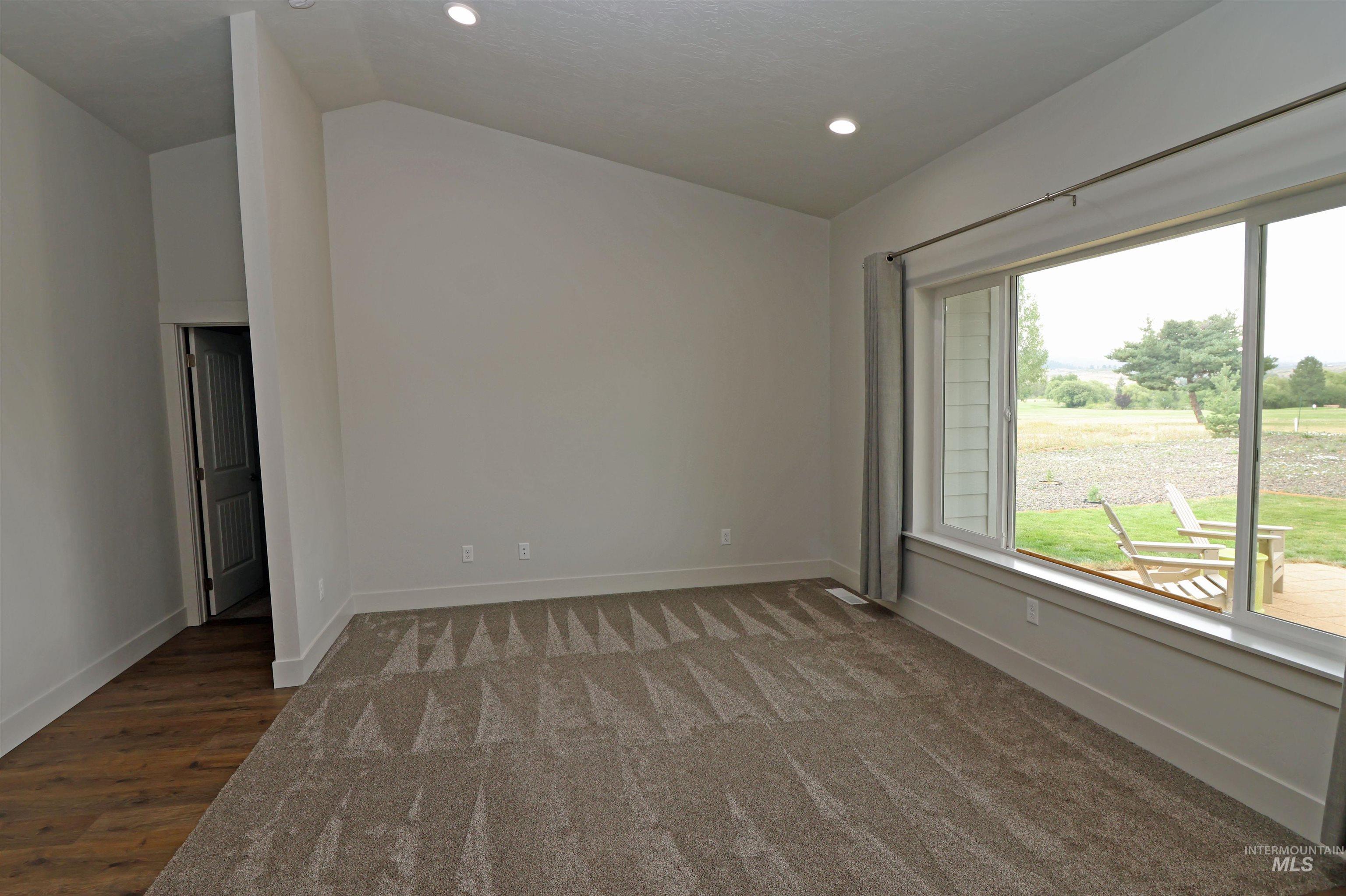 Spare room with vaulted ceiling, recessed lighting, and carpet flooring