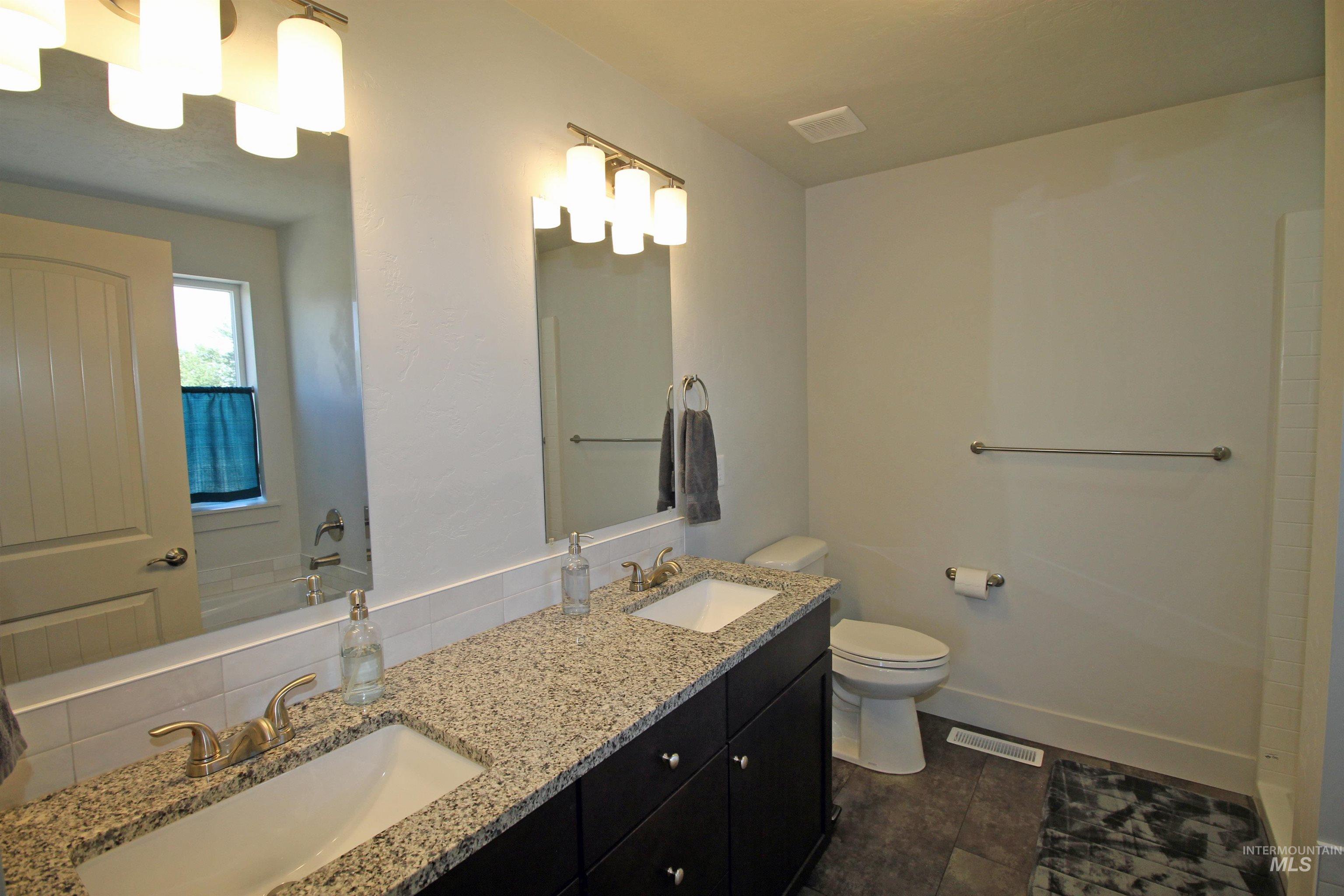 Bathroom with double vanity and tile patterned flooring