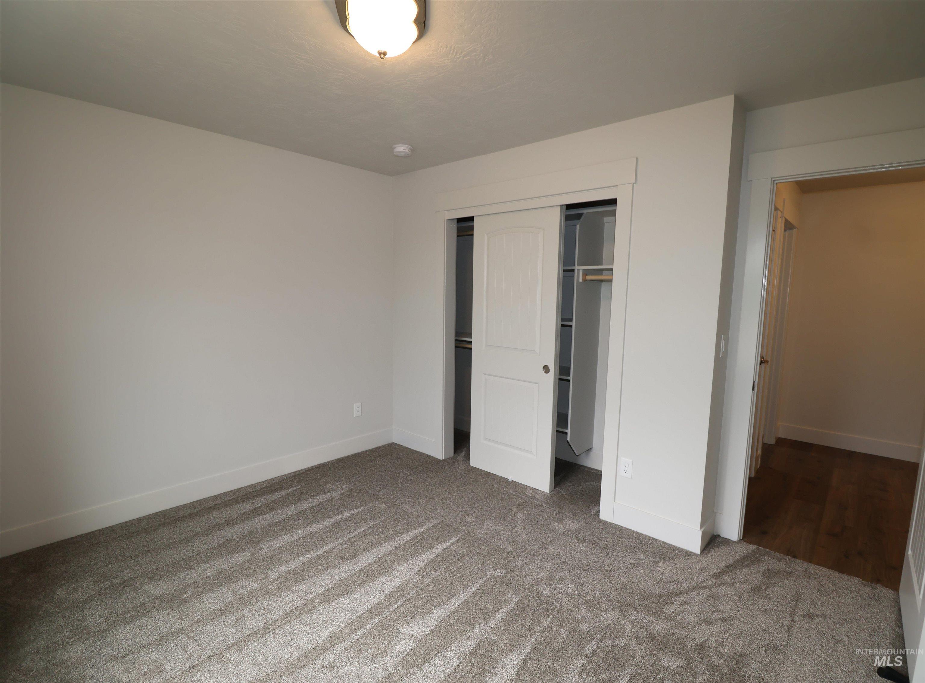 Unfurnished bedroom with carpet flooring and a closet