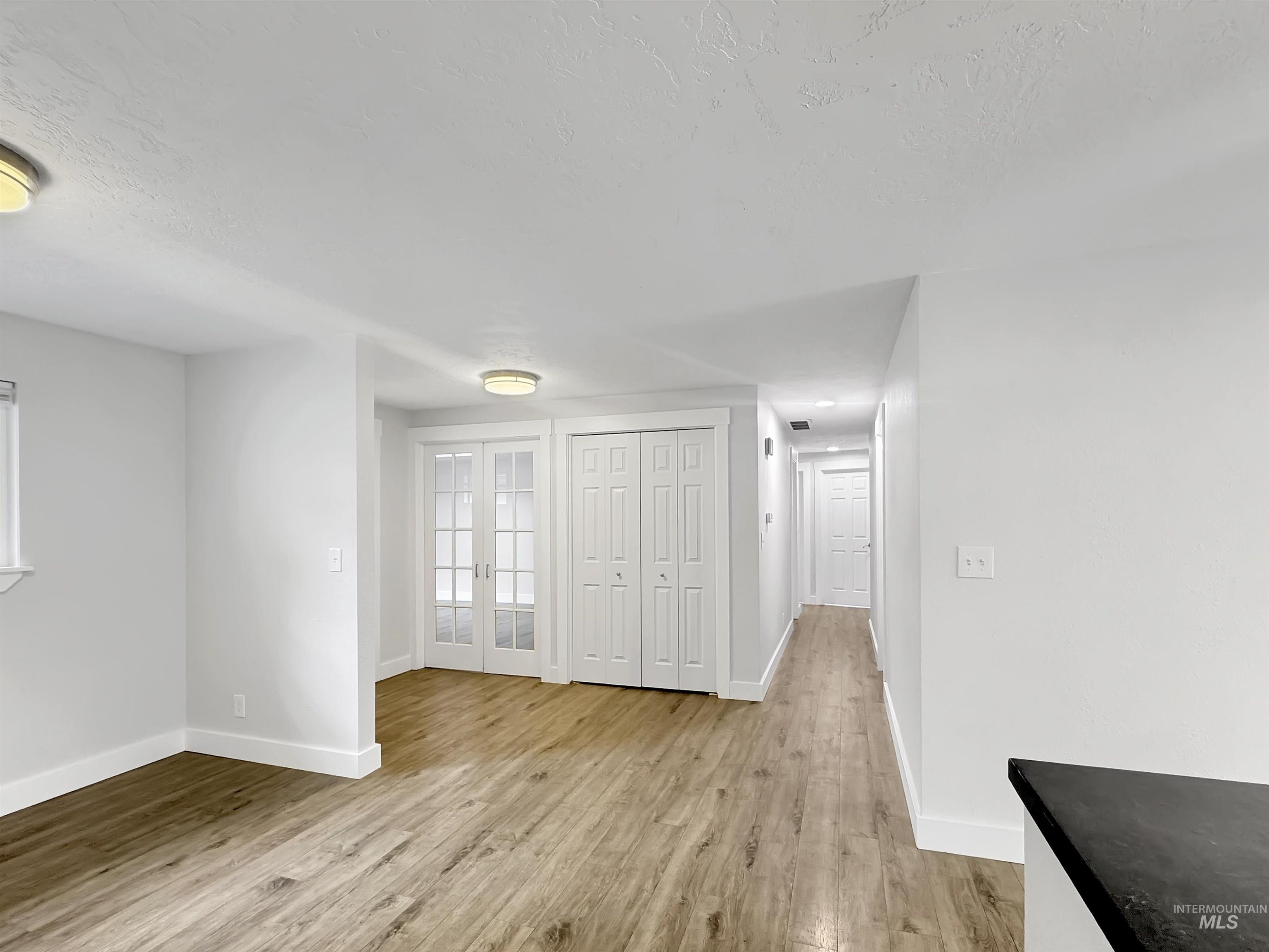 Bright interior with wood-finish flooring, white walls, and recessed lighting
