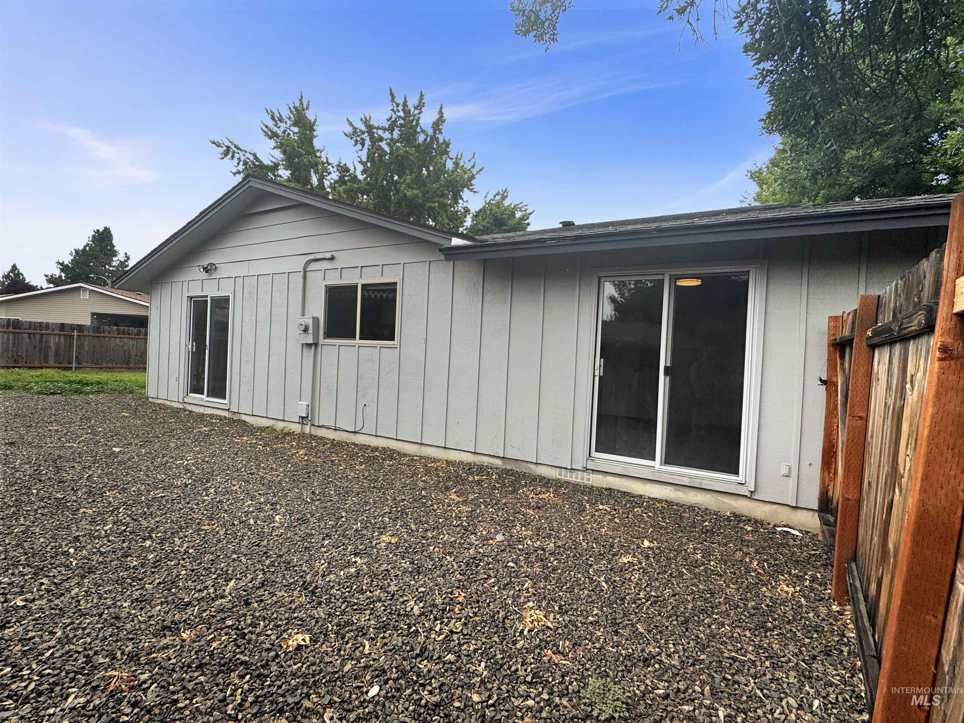 Rear exterior with light gray siding and two sliding glass doors