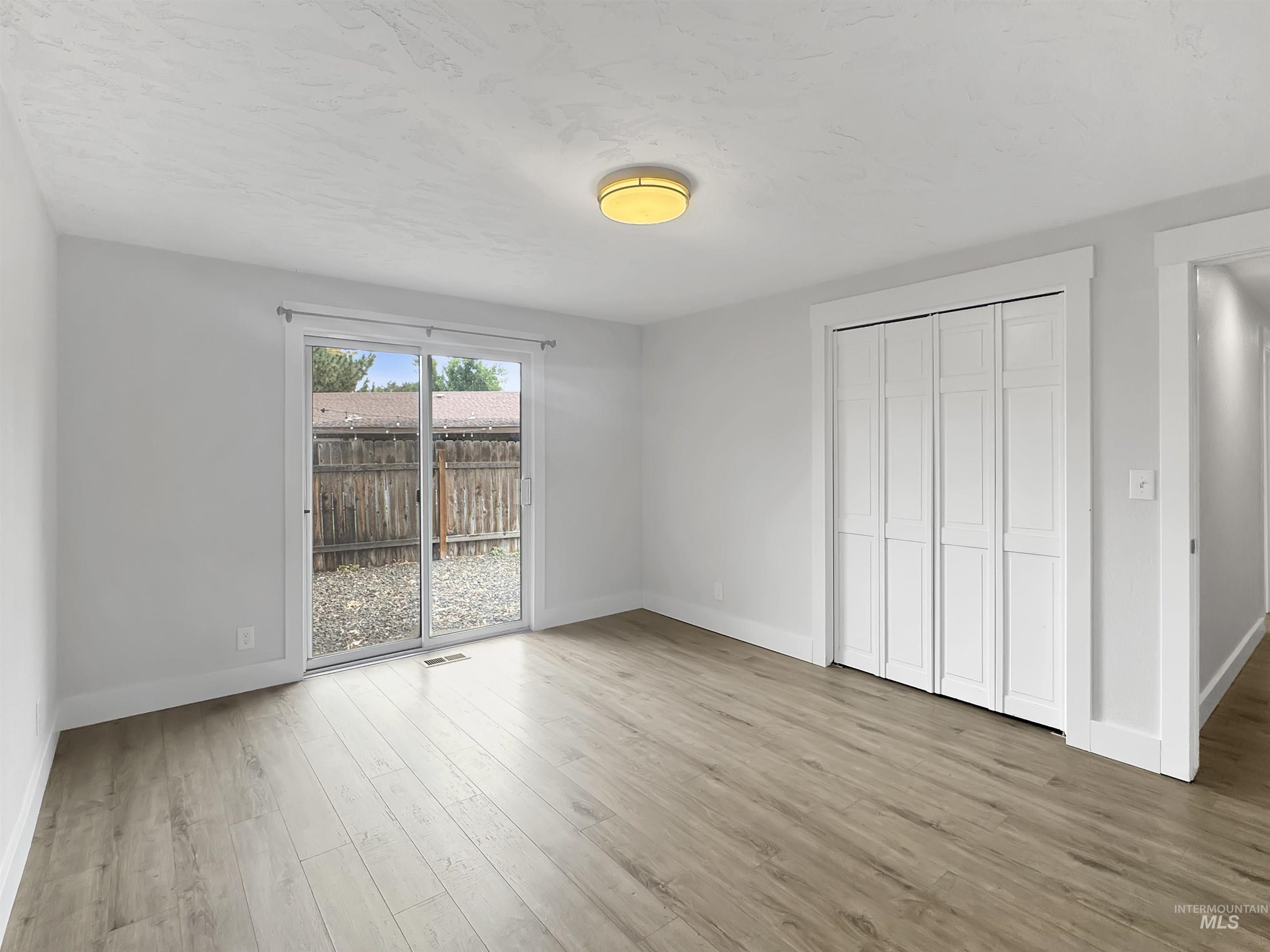 Light wood-finish flooring complements the neutral wall tones