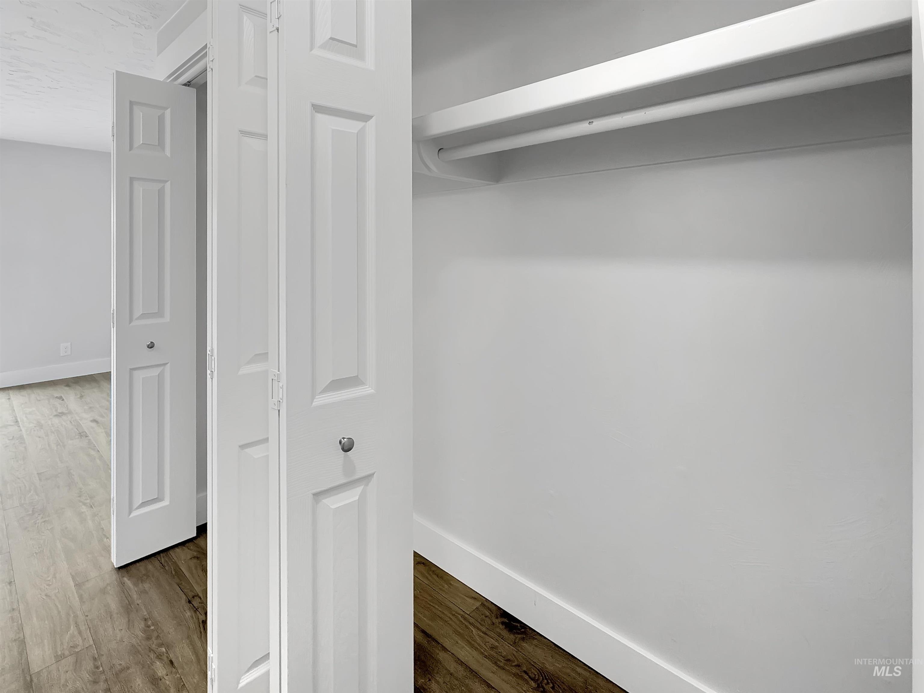 Interior closet featuring bifold doors, a white hanging rod, and a single shelf