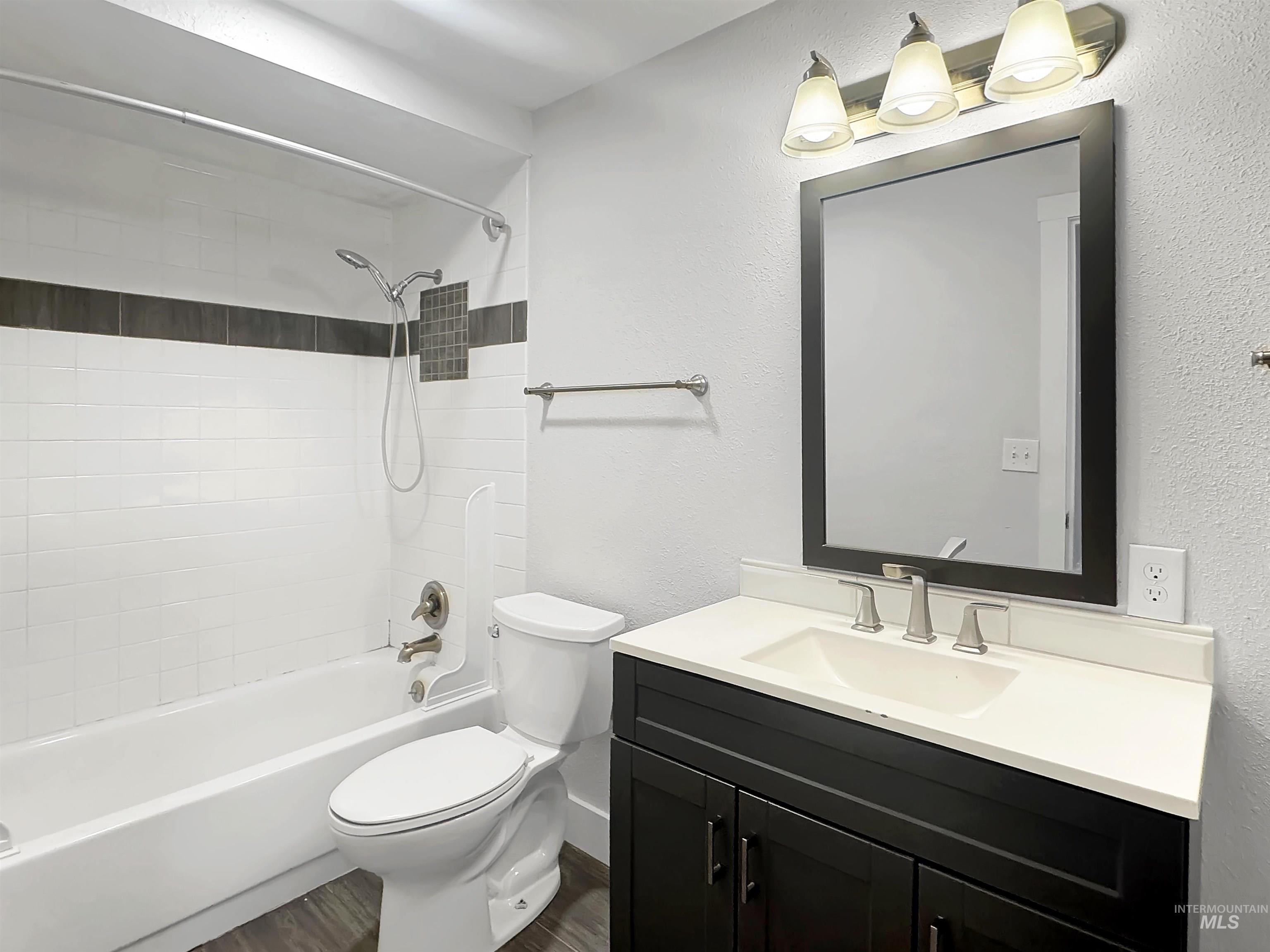 Bathroom featuring a dark wood-finish vanity with a white countertop, rectangular undermount sink, and brushed nickel fixtures