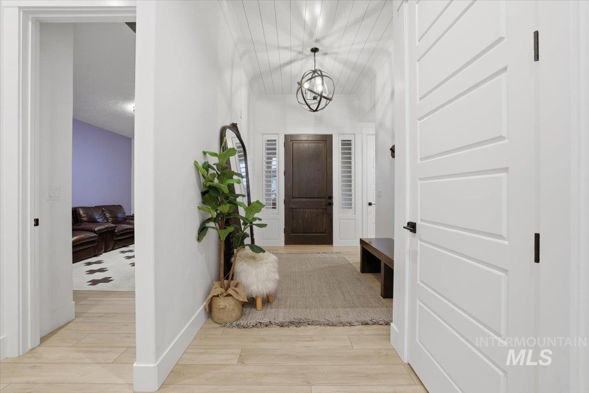Foyer with light wood-style flooring and a chandelier