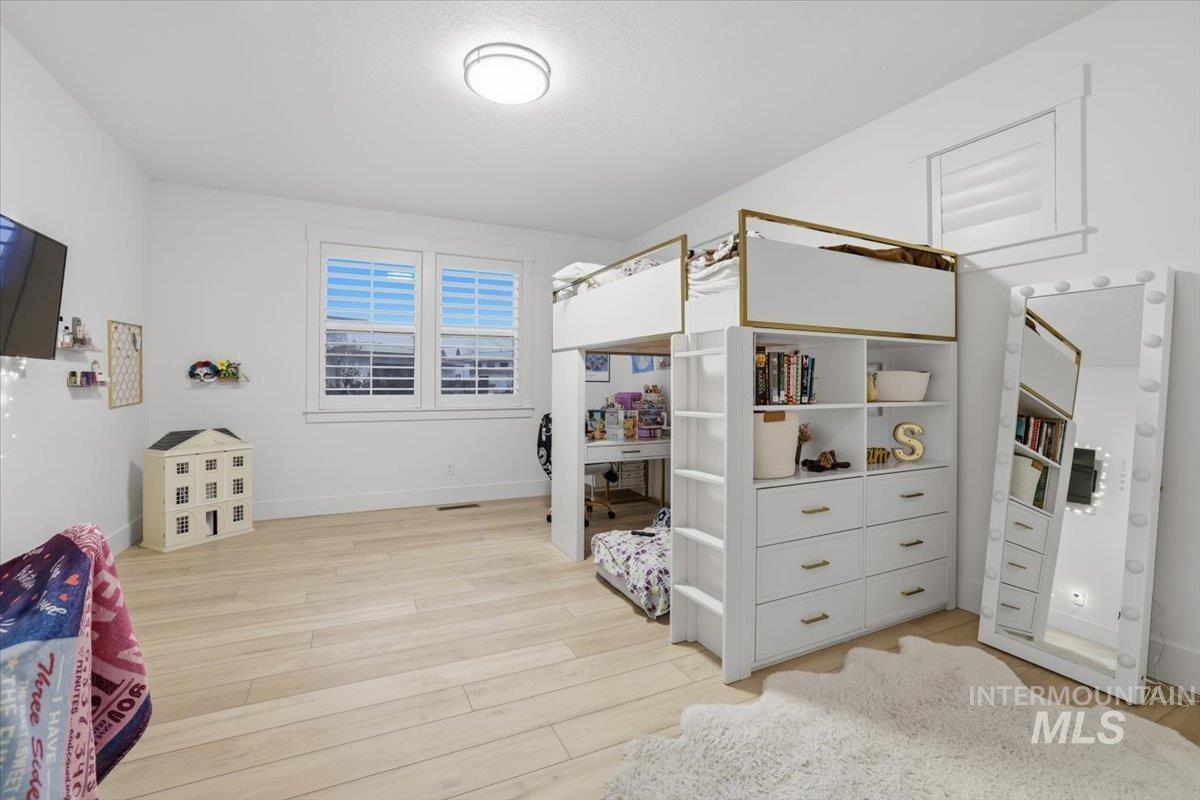 Bedroom with light wood-type flooring and baseboards