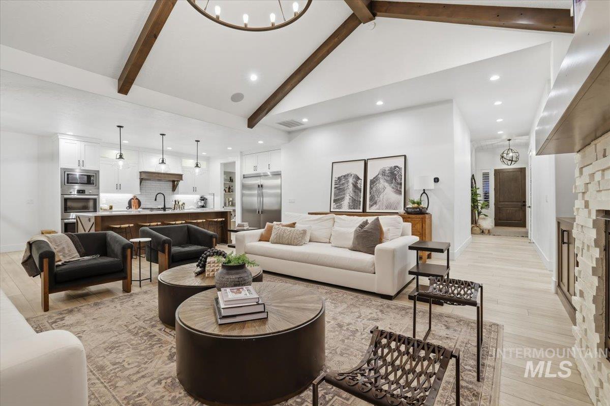Living area with a chandelier, light wood-style floors, recessed lighting, and a fireplace