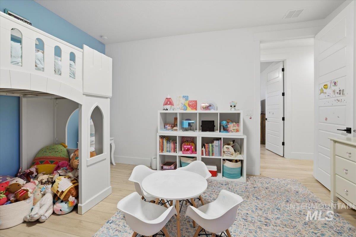 Recreation room featuring light wood-style floors and baseboards