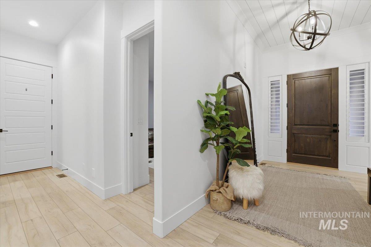 Foyer featuring light wood-type flooring and a chandelier