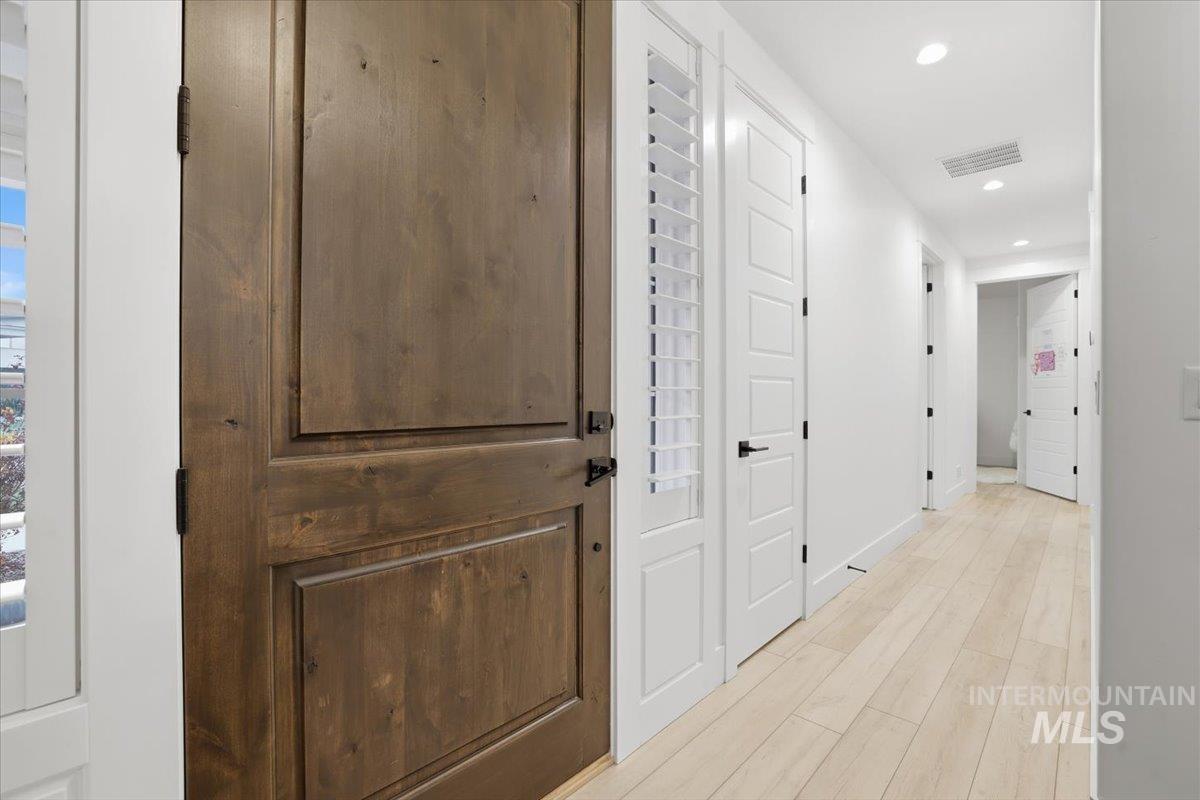 Corridor with recessed lighting and light wood-type flooring