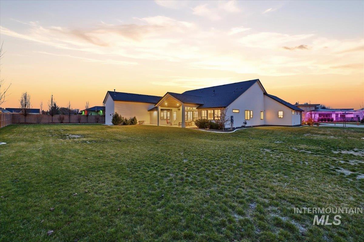 Back of house at dusk with a patio and stucco siding