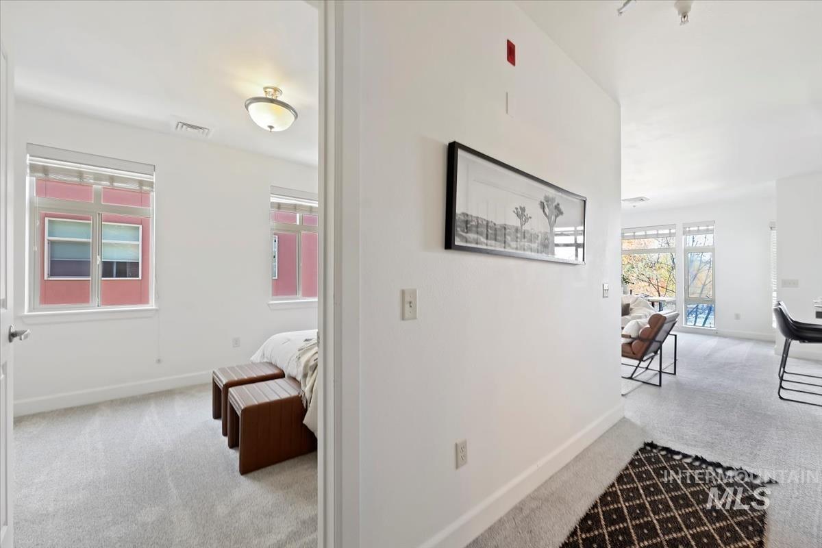 Hall featuring light carpet and baseboards