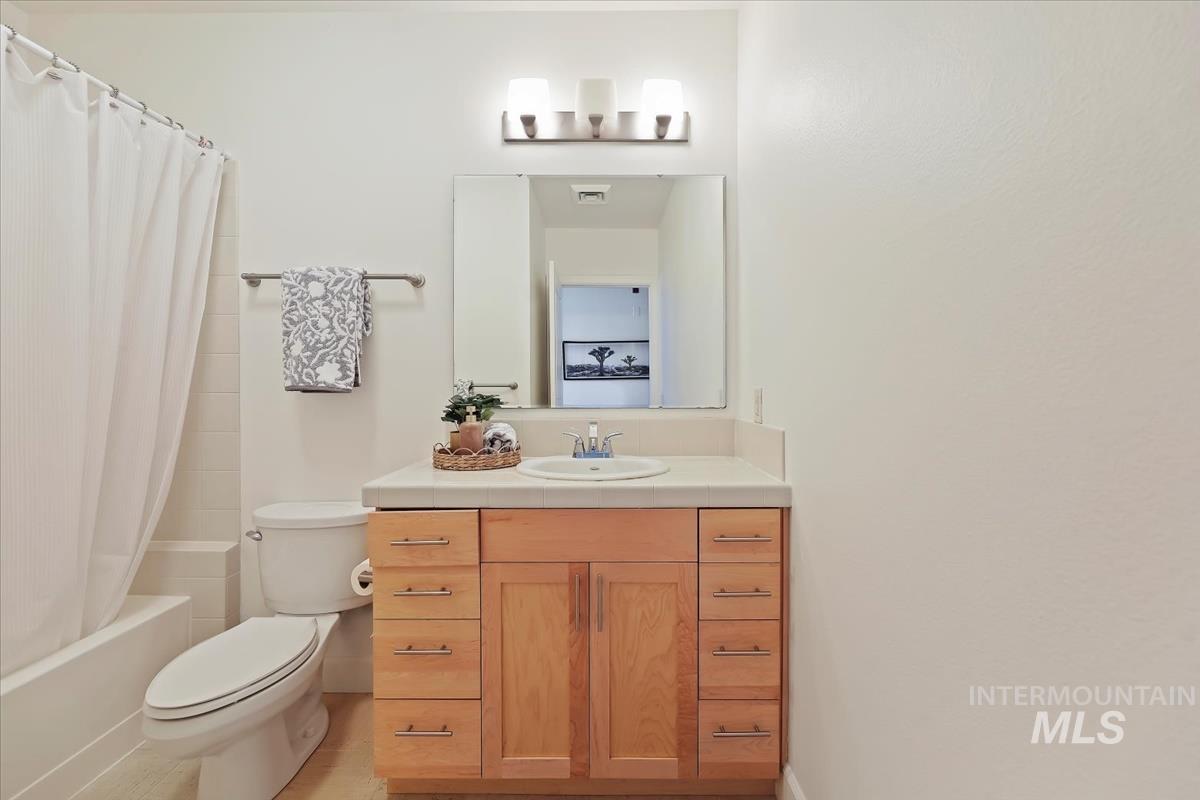 Bathroom with vanity and shower / tub combo with curtain