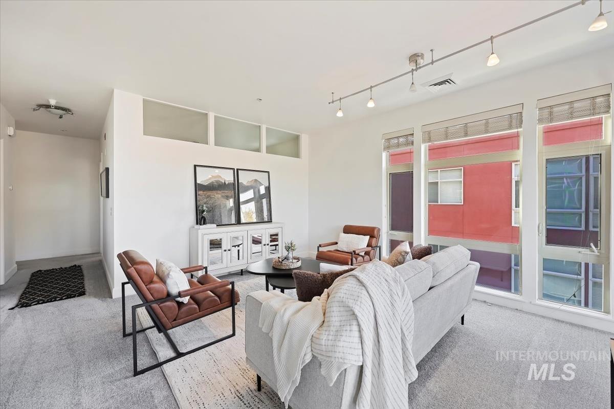 Living room with carpet flooring and track lighting