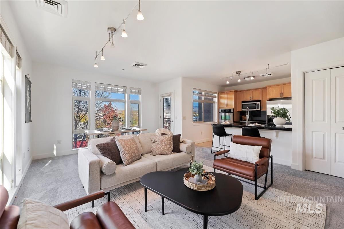 Living area featuring light colored carpet and track lighting