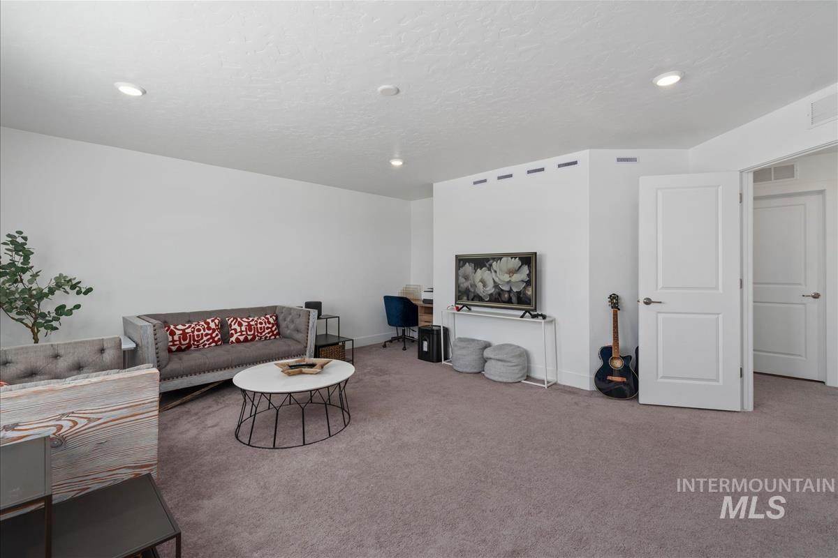 Carpeted living space featuring recessed lighting and white walls