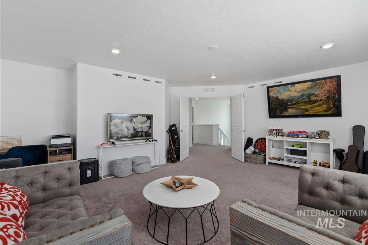 Spacious carpeted room featuring recessed lighting and a neutral color palette