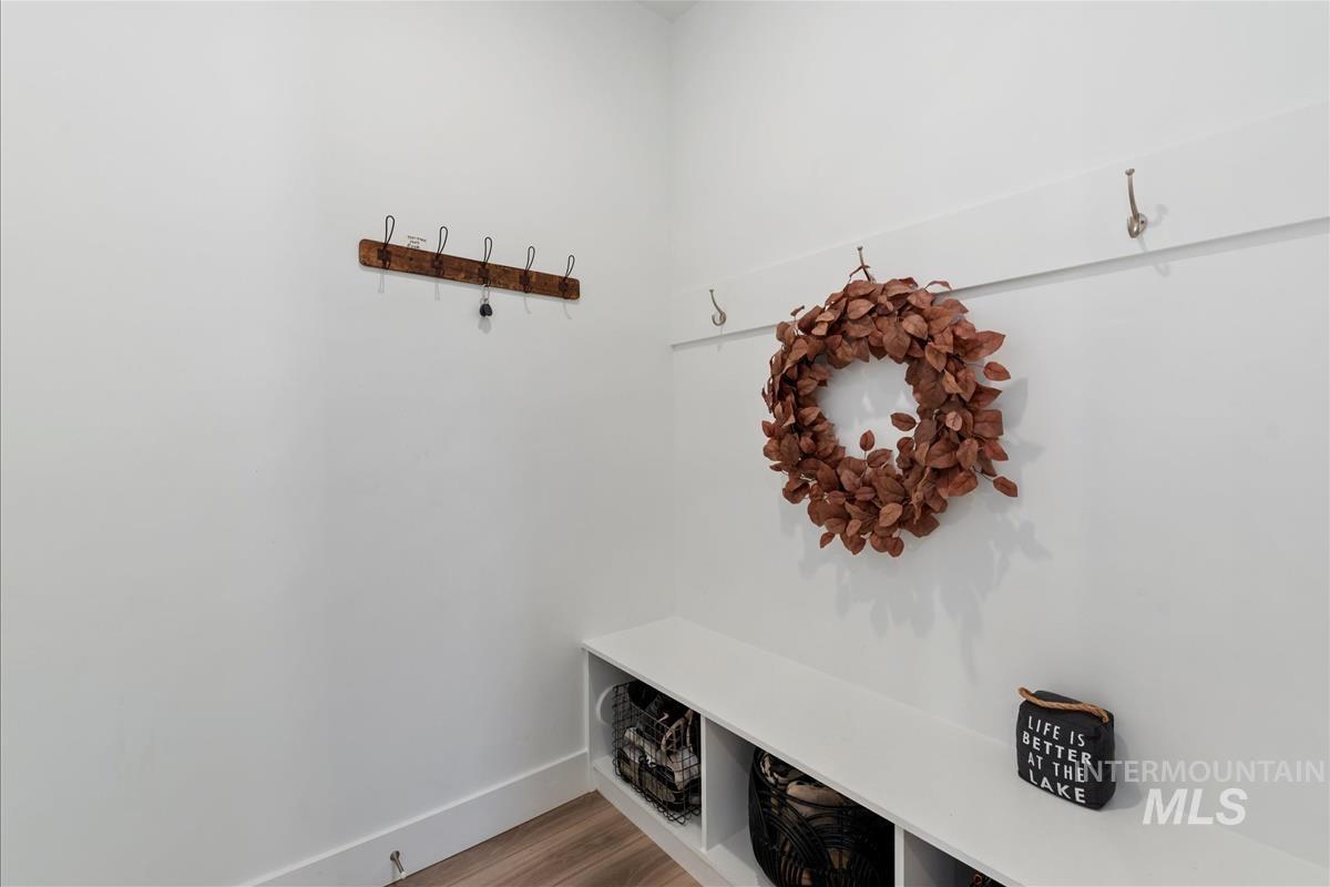 Built-in bench seating with cubby storage, wall-mounted coat hooks, and light wood-finish flooring